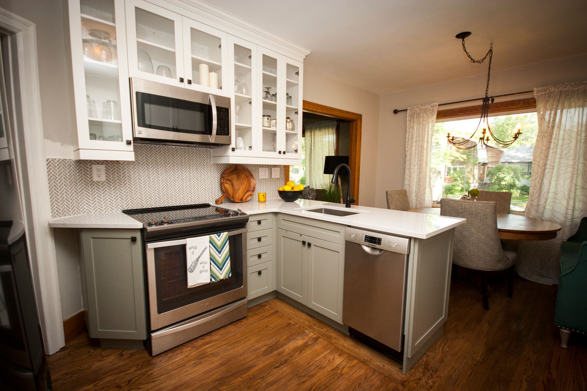 A kitchen with stainless steel appliances and white cabinets.