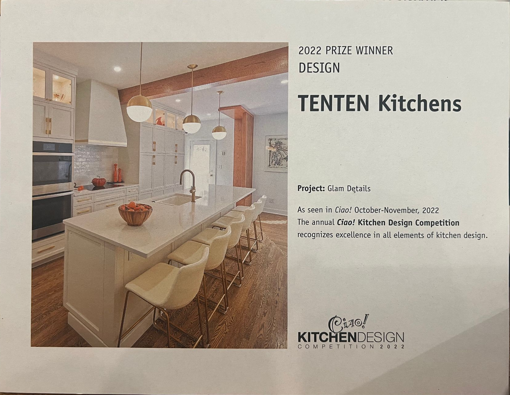 A sign displays a photo of a modern kitchen with a white island, bar stools, and the text