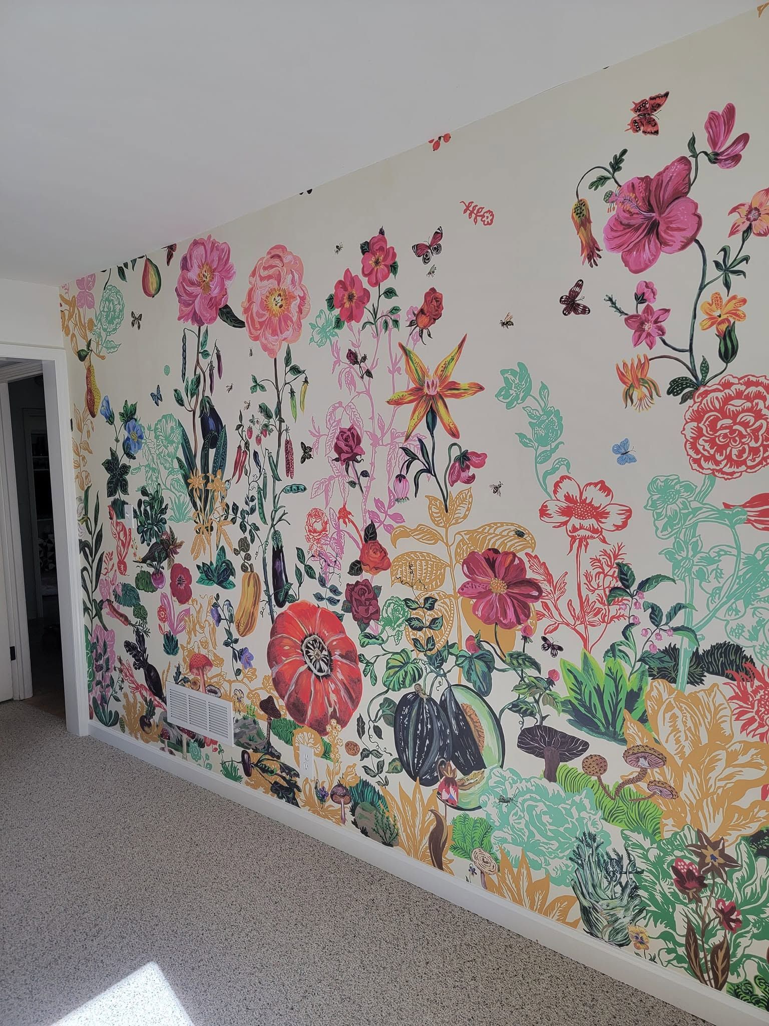Large colorful floral mural covering a hallway wall with pink, yellow, and green blossoms