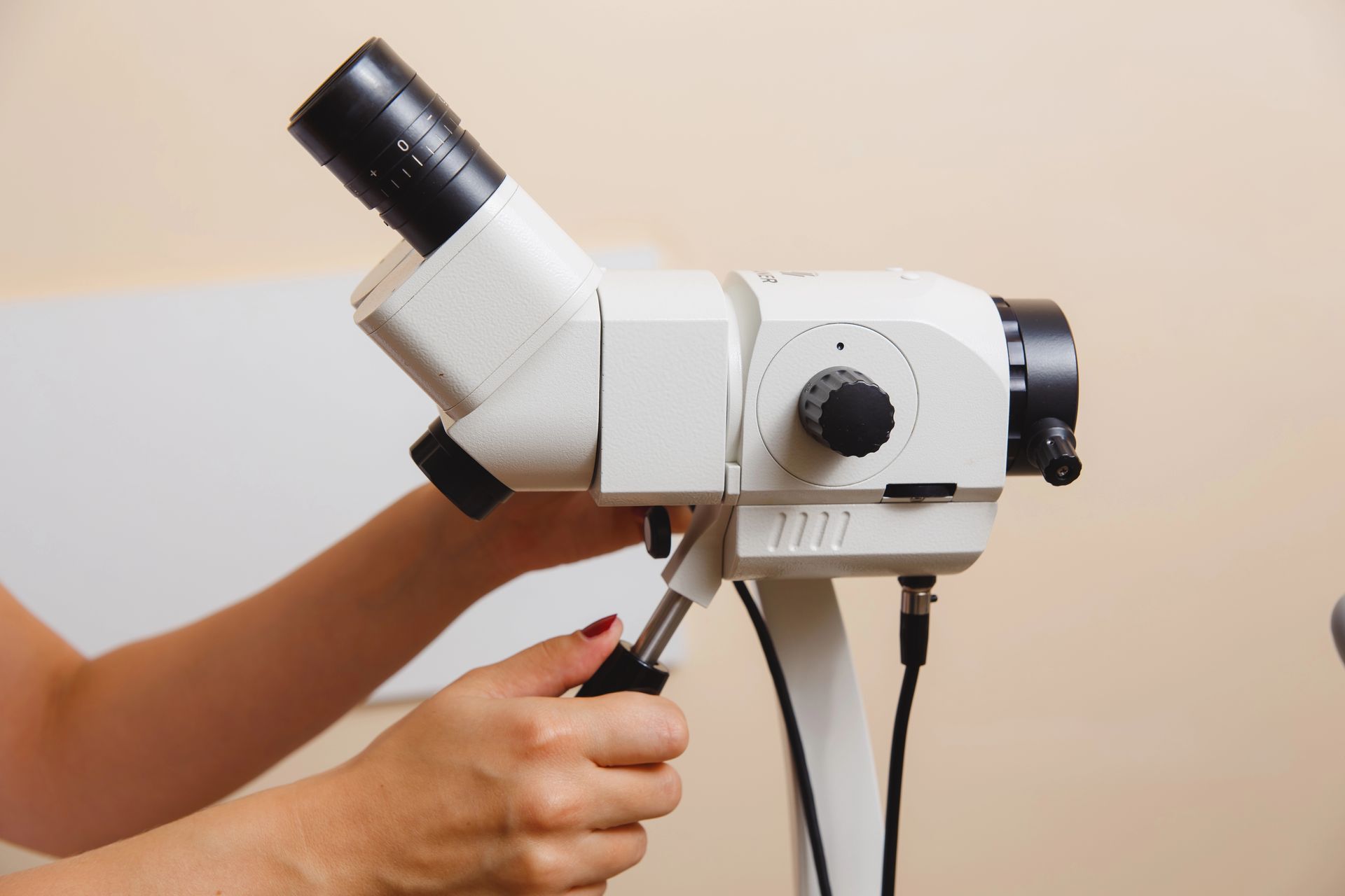 Una mujer sostiene un microscopio en sus manos.