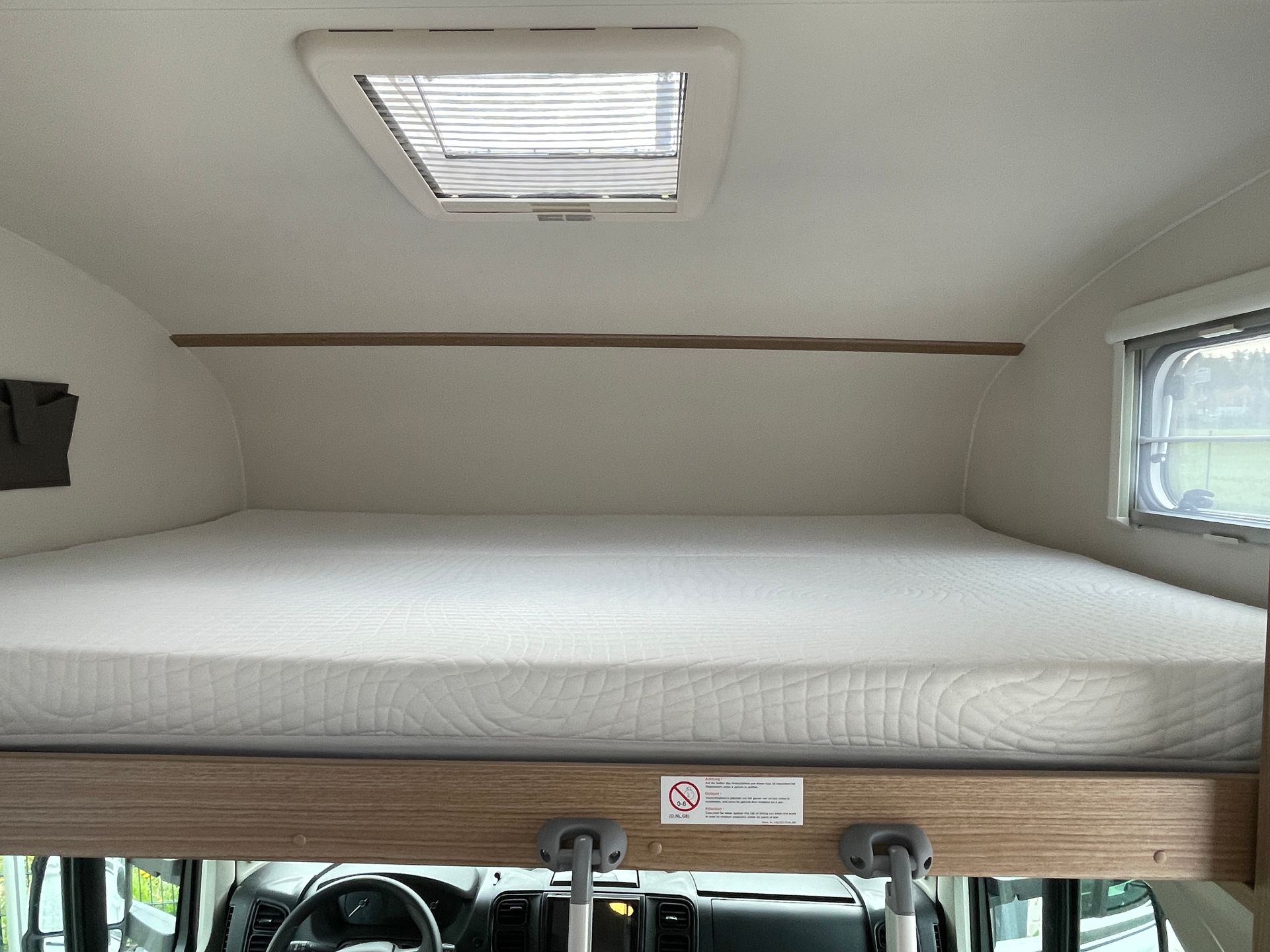 There is a bed in the back of a camper van.