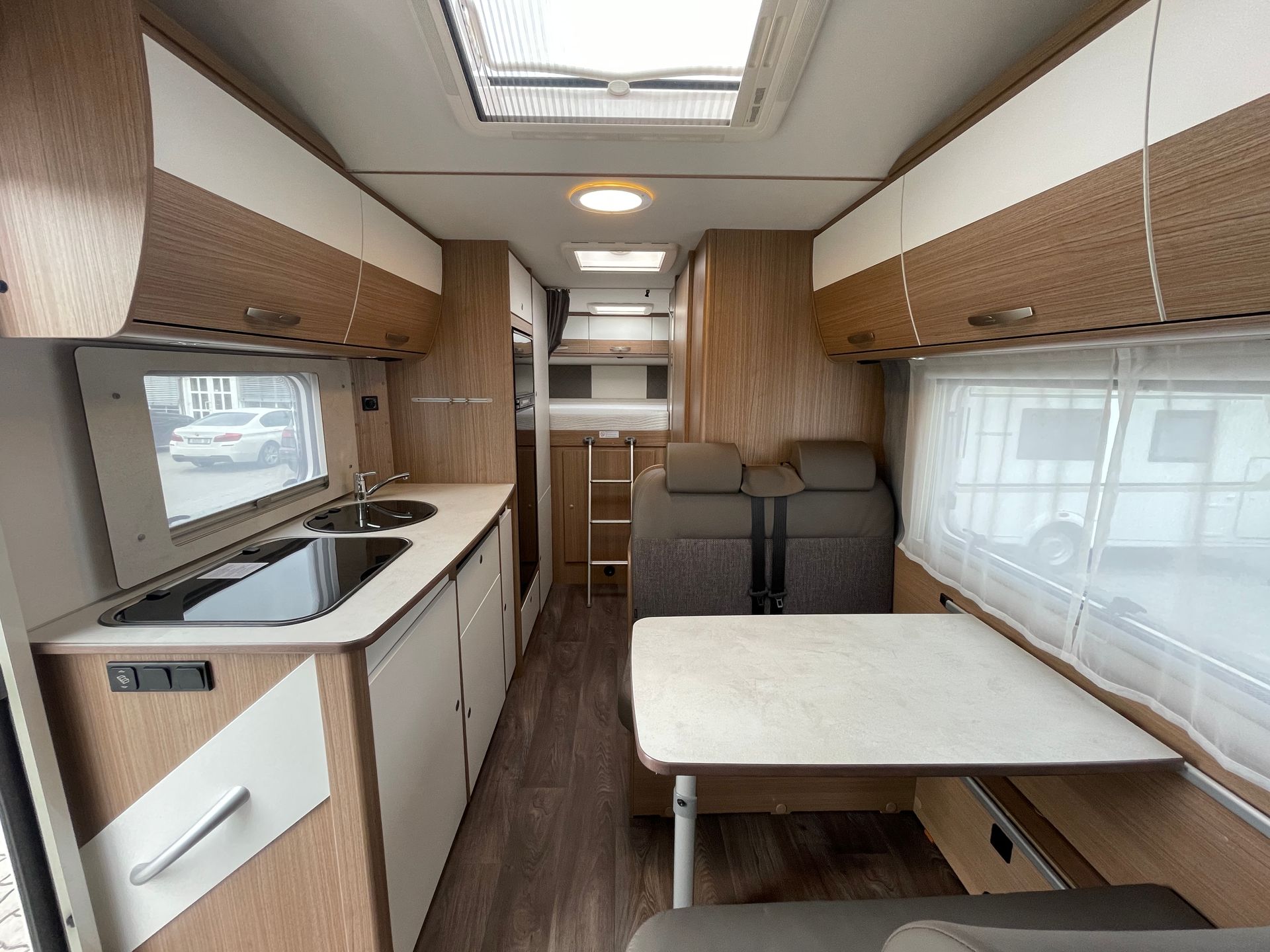The inside of a camper van with a table and a sink.