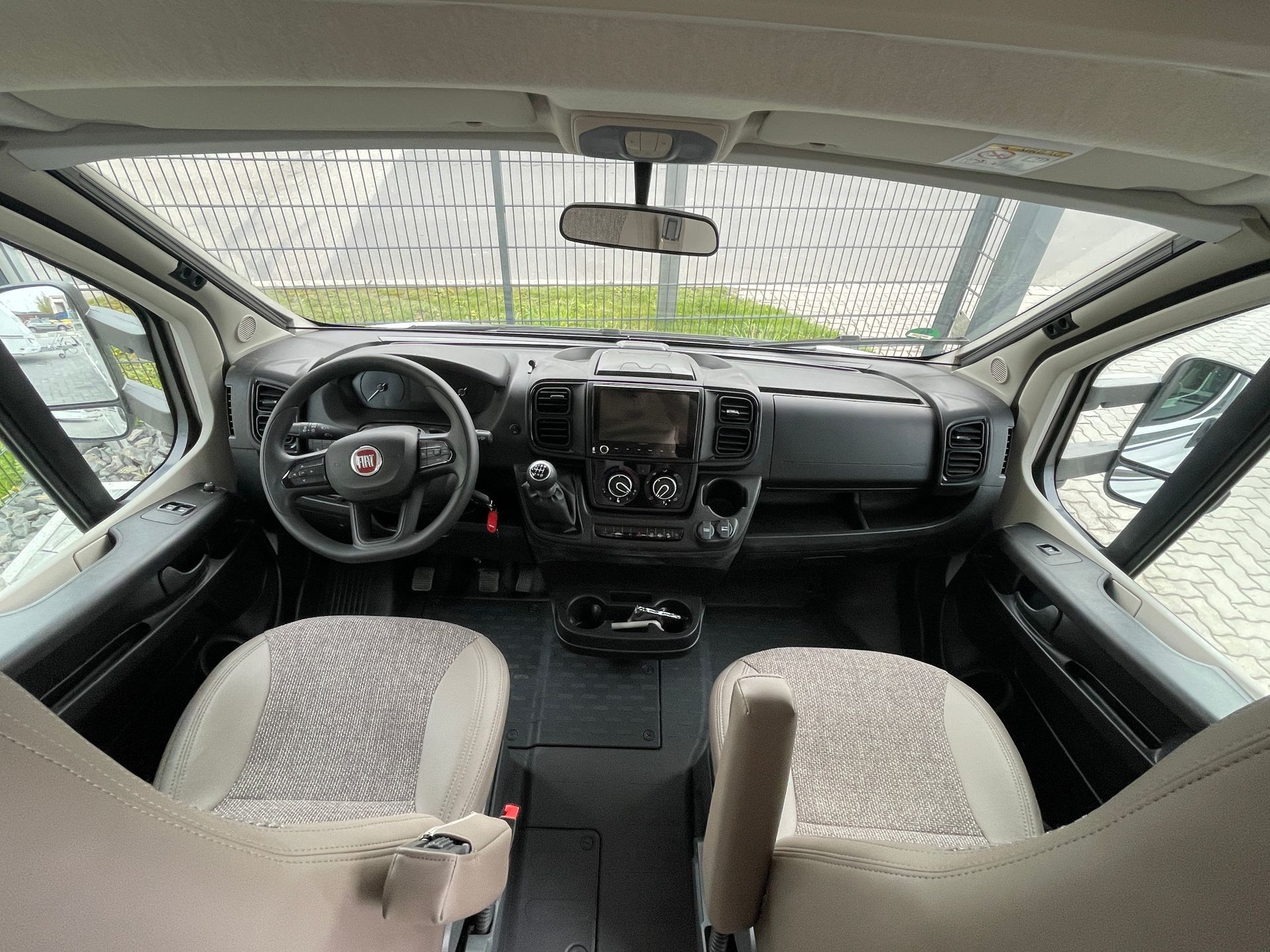 The interior of a van with a steering wheel and seats.