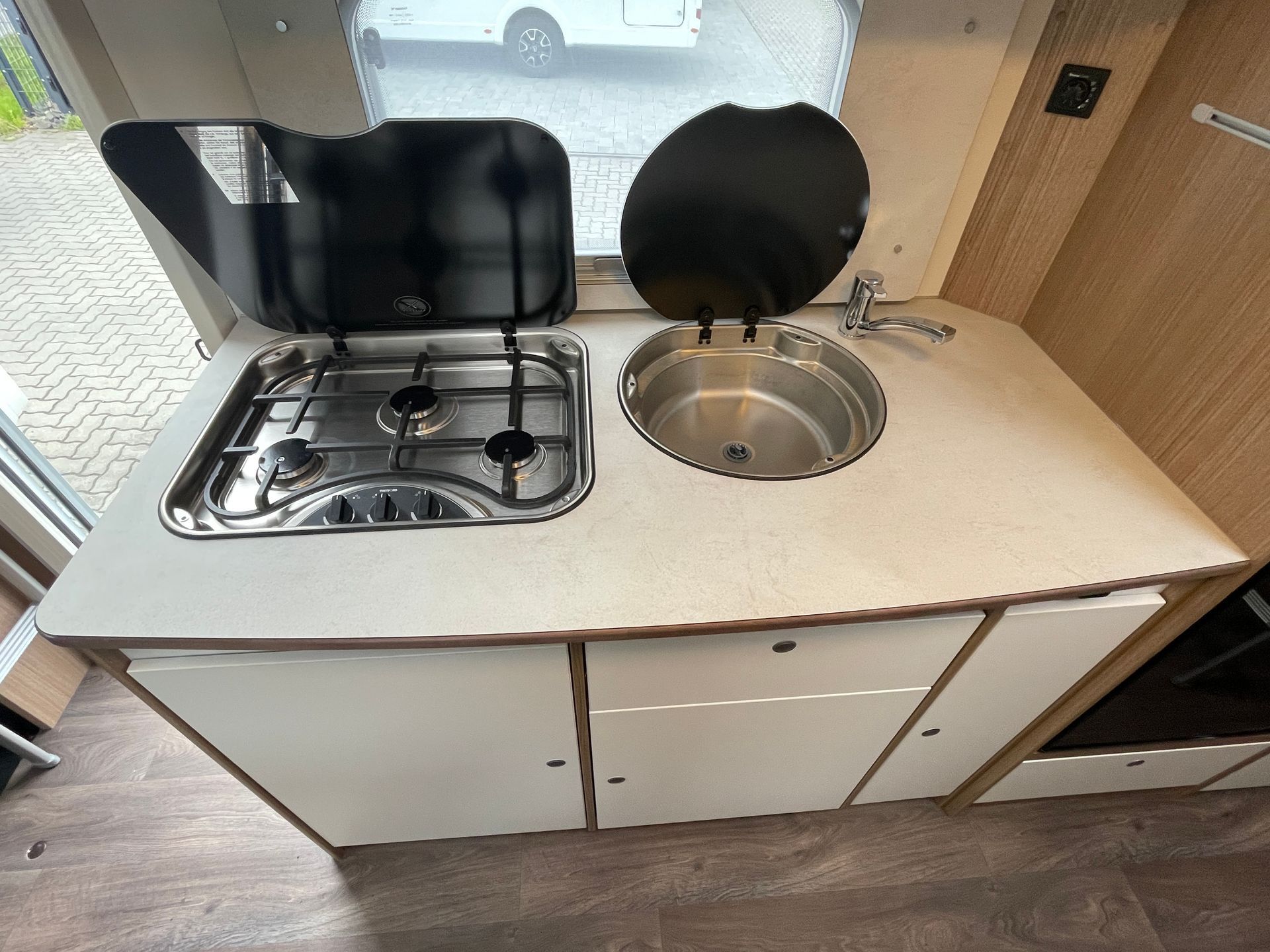 A kitchen in a camper with a stove and sink