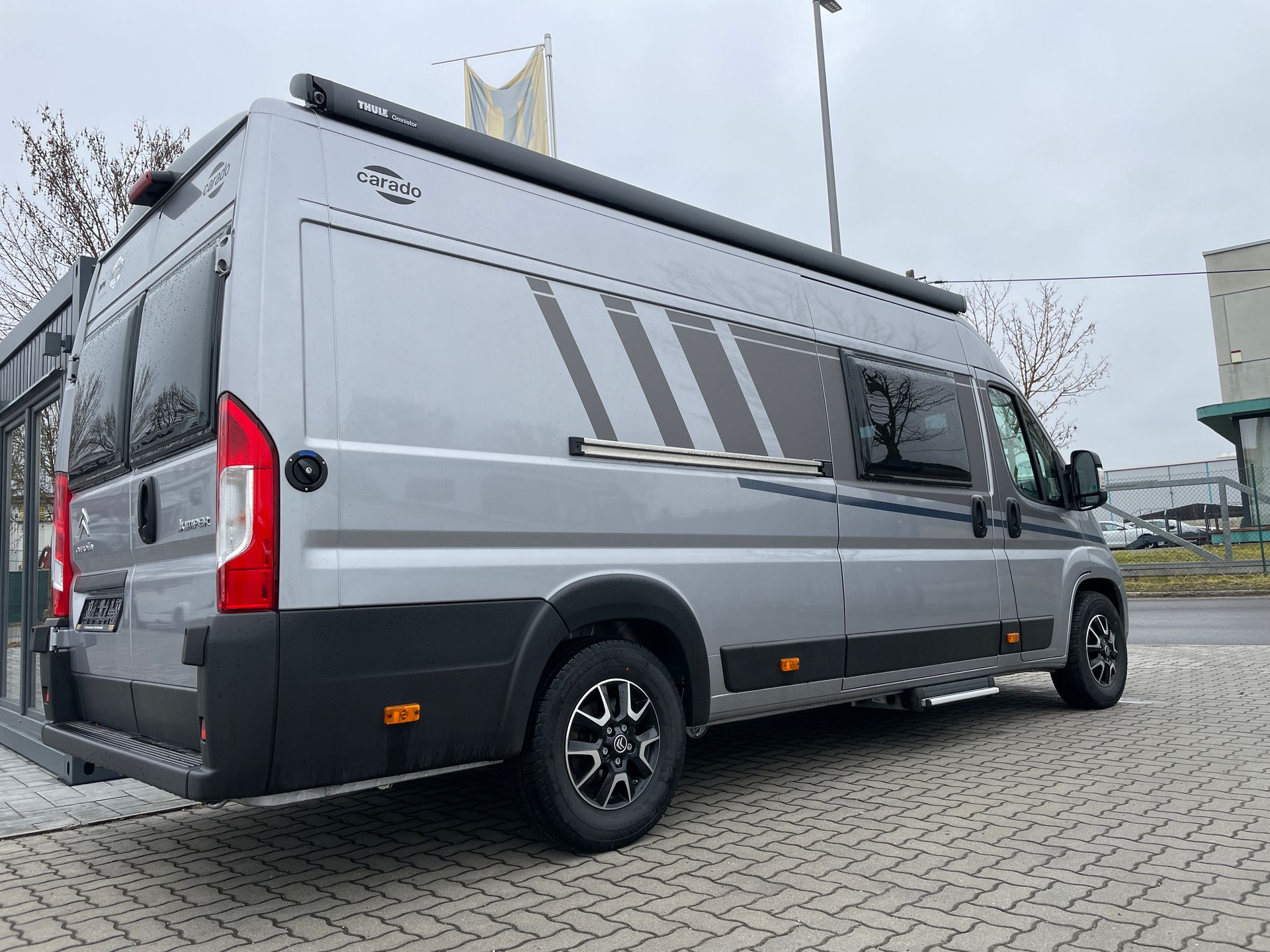 Ein grauer Lieferwagen steht am Straßenrand.