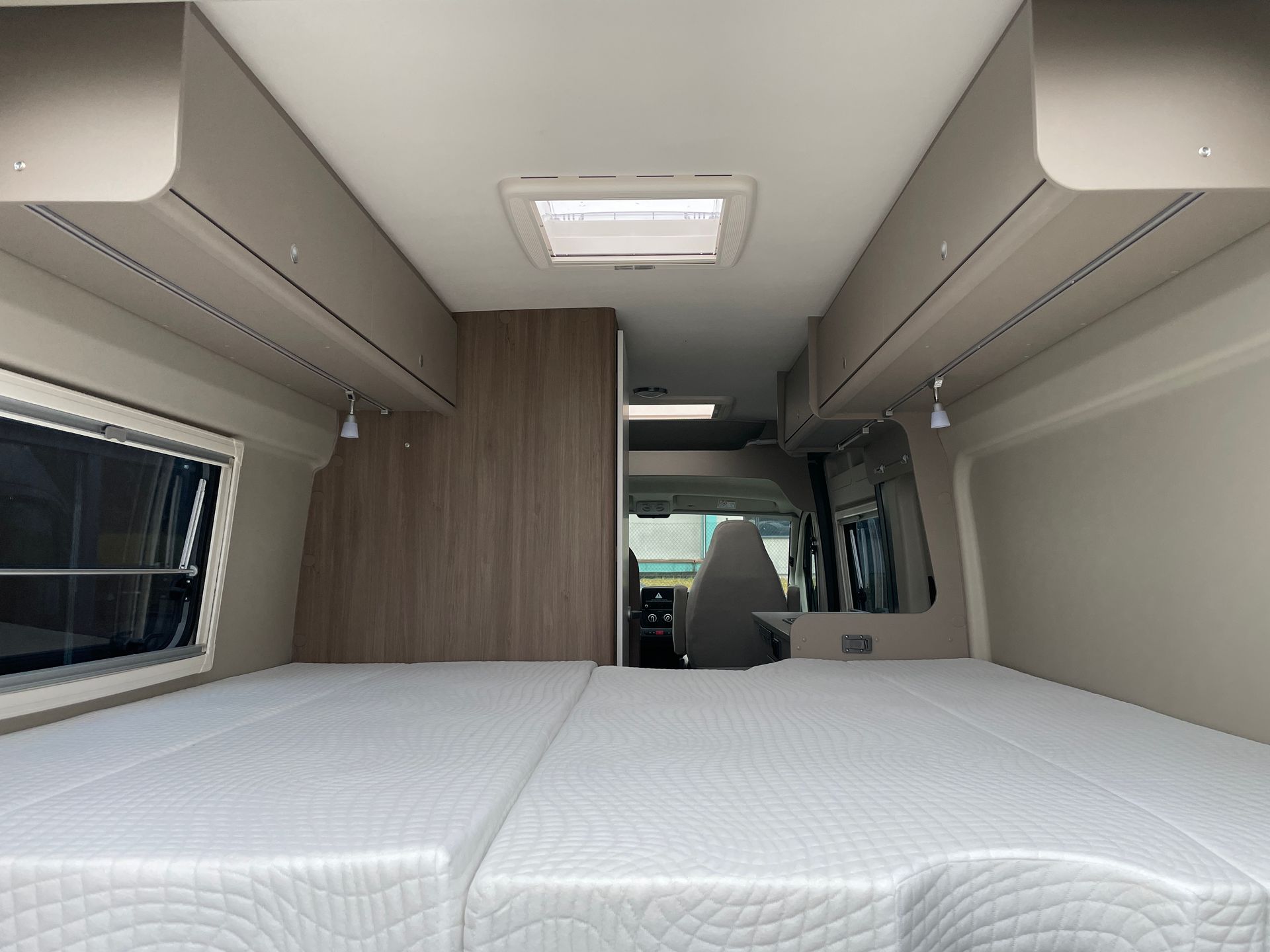 Das Innere eines Wohnmobils mit einem Bett und einem Fenster.