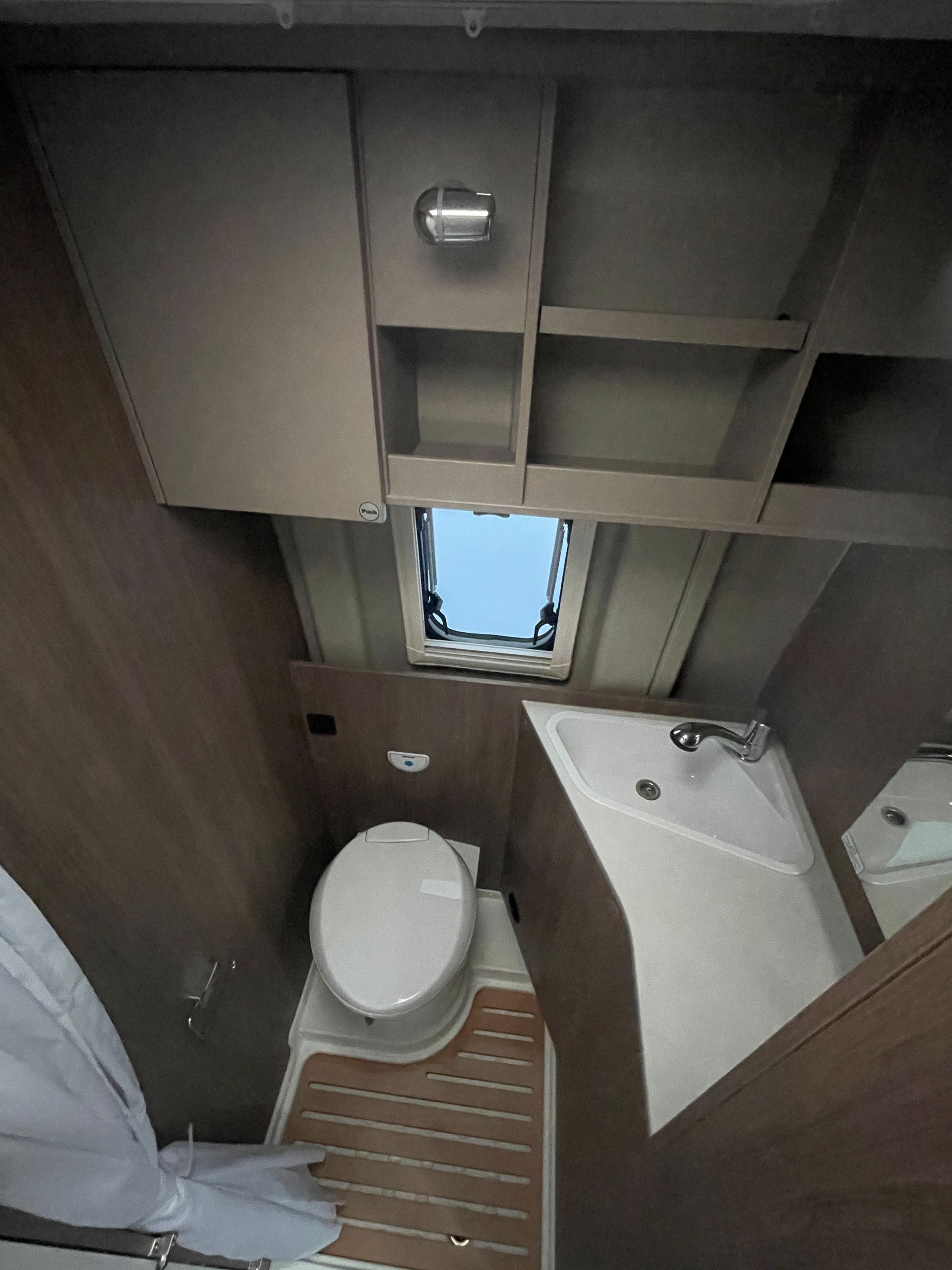 Ein Badezimmer mit Toilette, Waschbecken und Spiegel