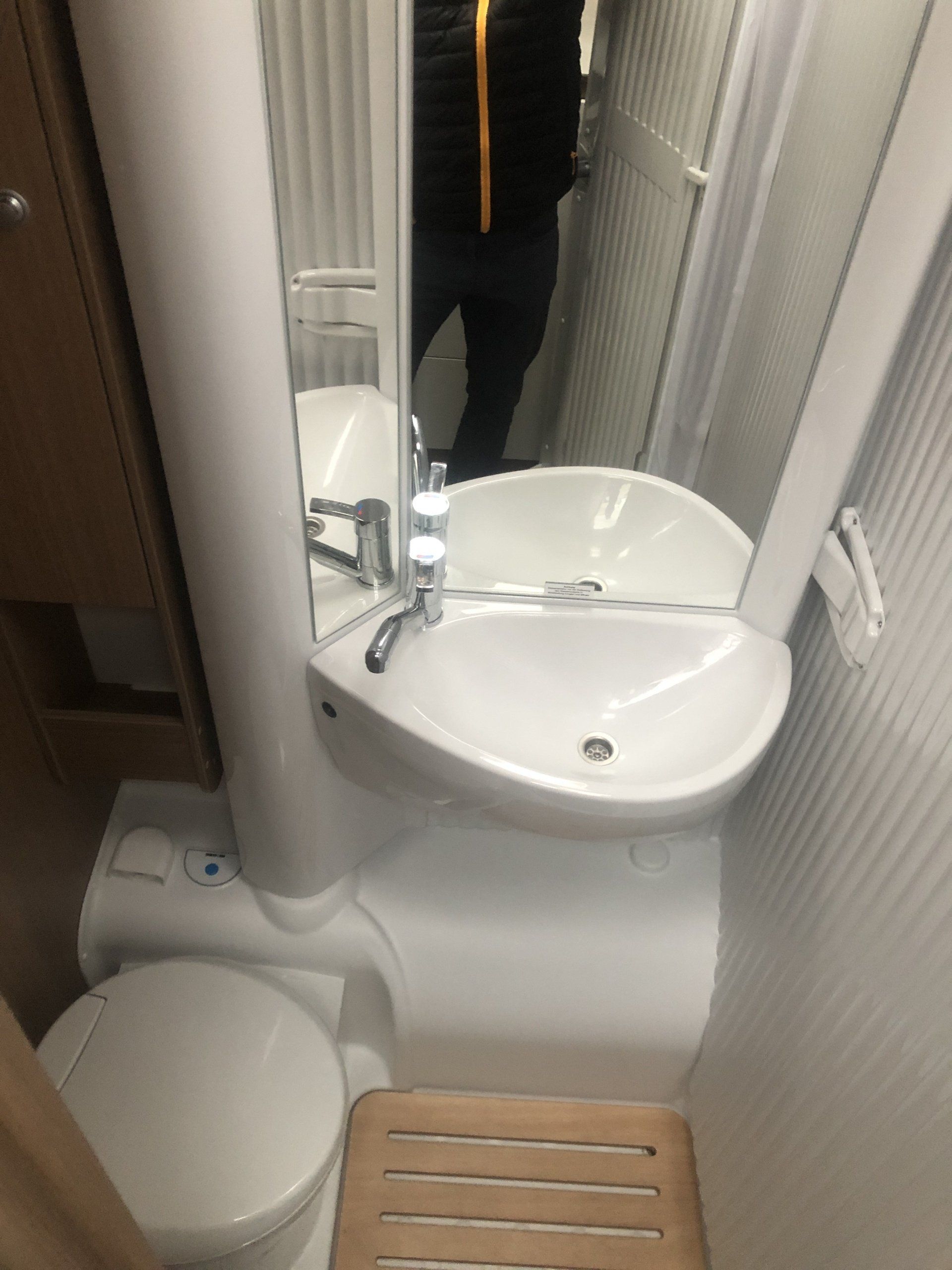 Ein Badezimmer mit Waschbecken, Toilette und Spiegel.