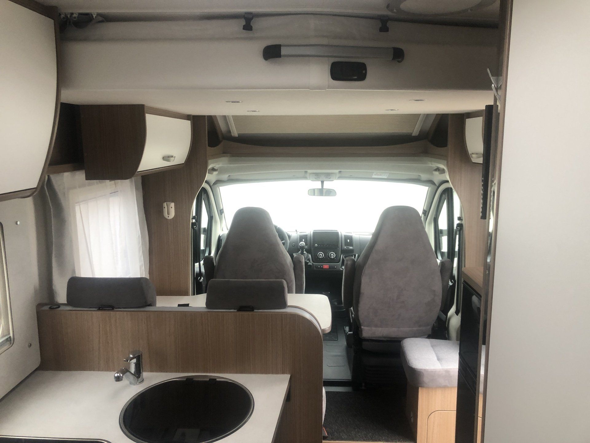Das Innere eines Wohnmobils mit Waschbecken und Stühlen.