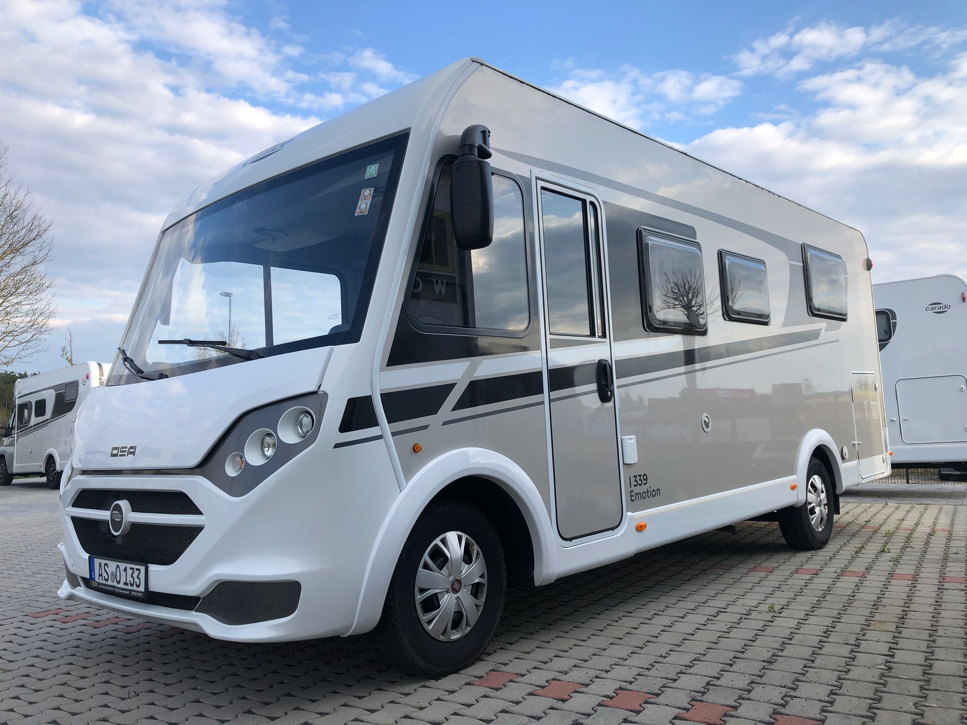 A white rv is parked in a parking lot.