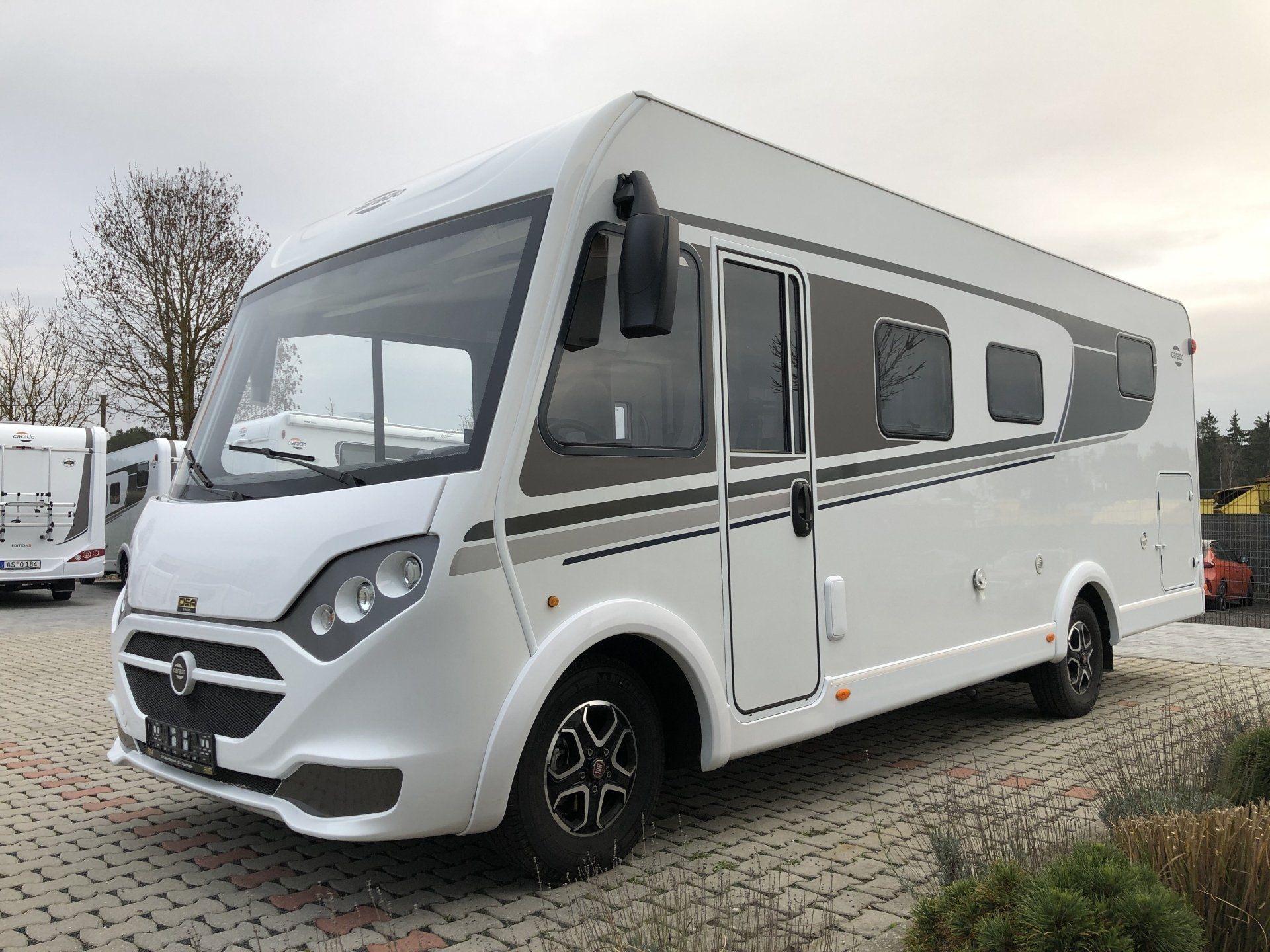 Ein weißes Wohnmobil steht auf einem Parkplatz.