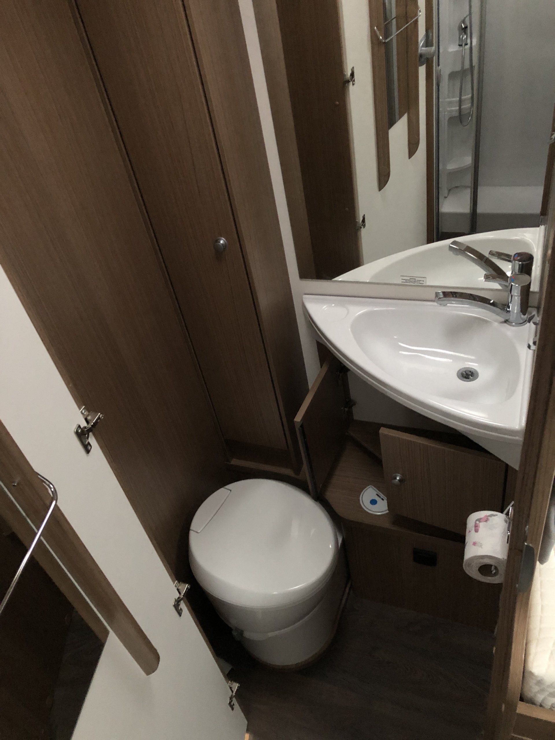 Ein Badezimmer mit Toilette, Waschbecken und Spiegel