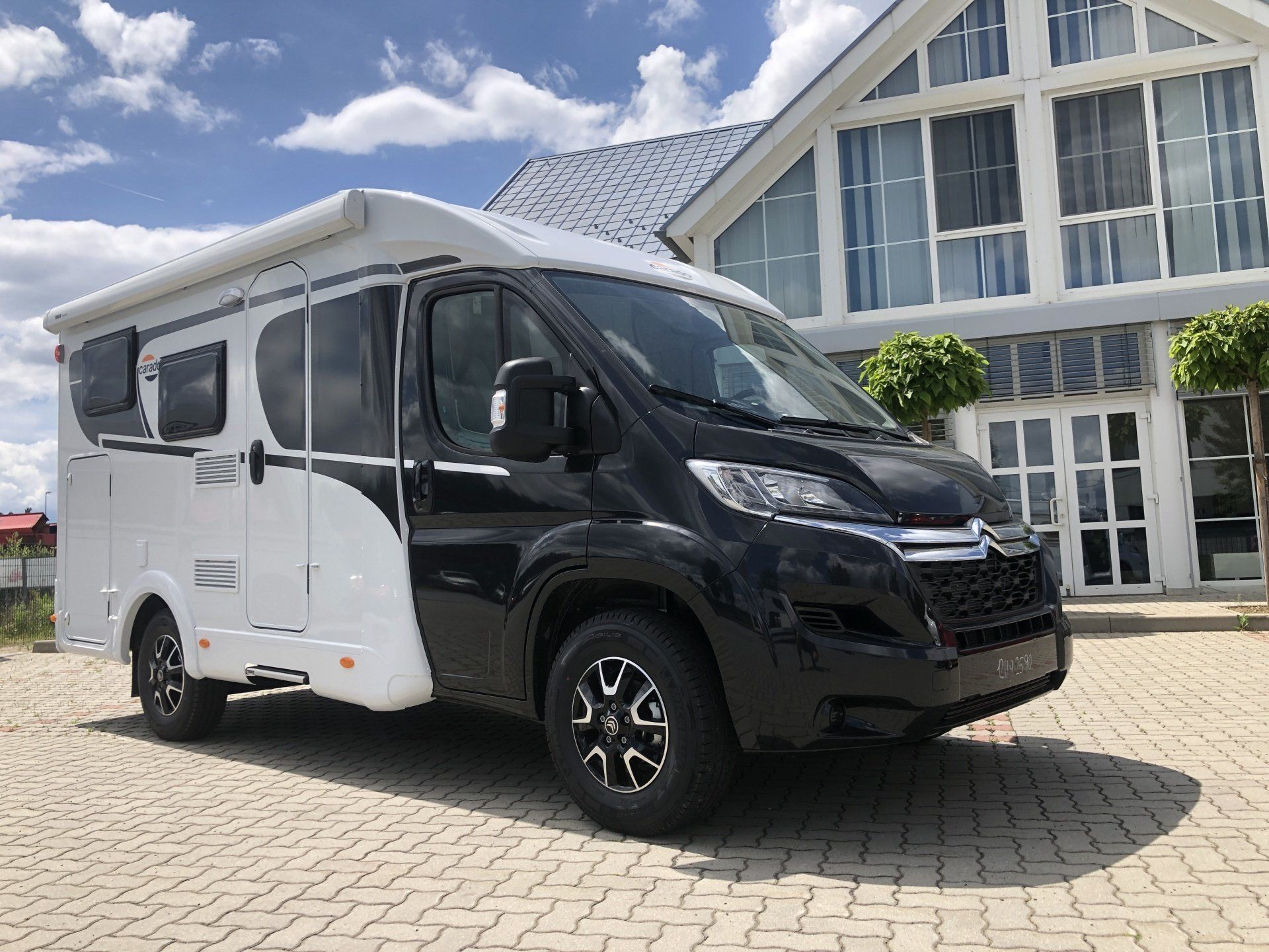 Ein schwarz - weißer Lieferwagen ist vor einem Gebäude geparkt.
