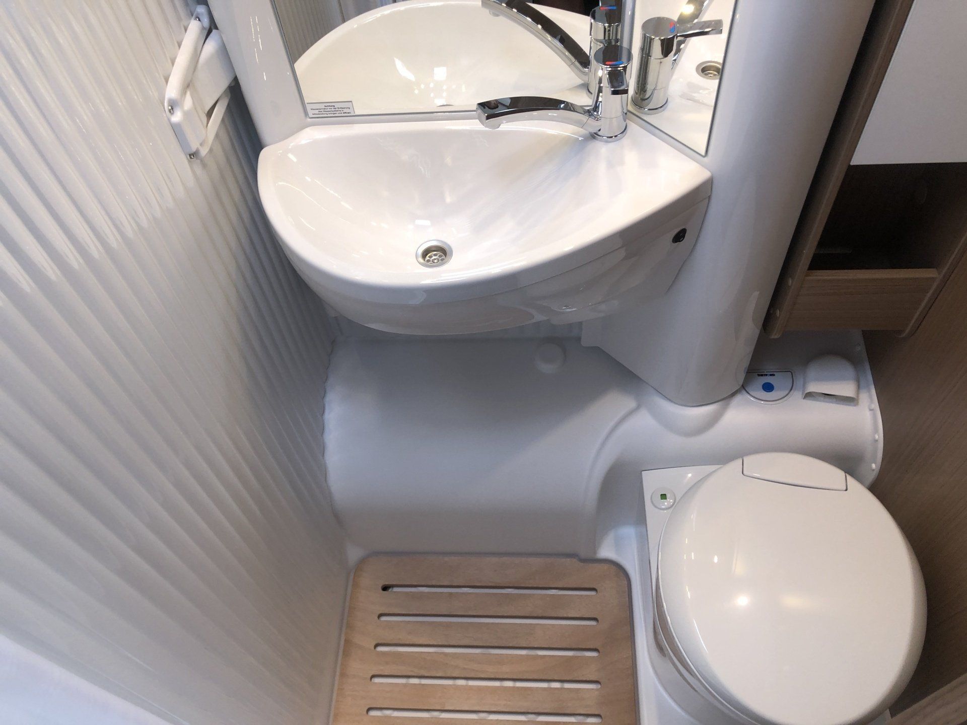 Ein Badezimmer mit Toilette, Waschbecken und Spiegel.