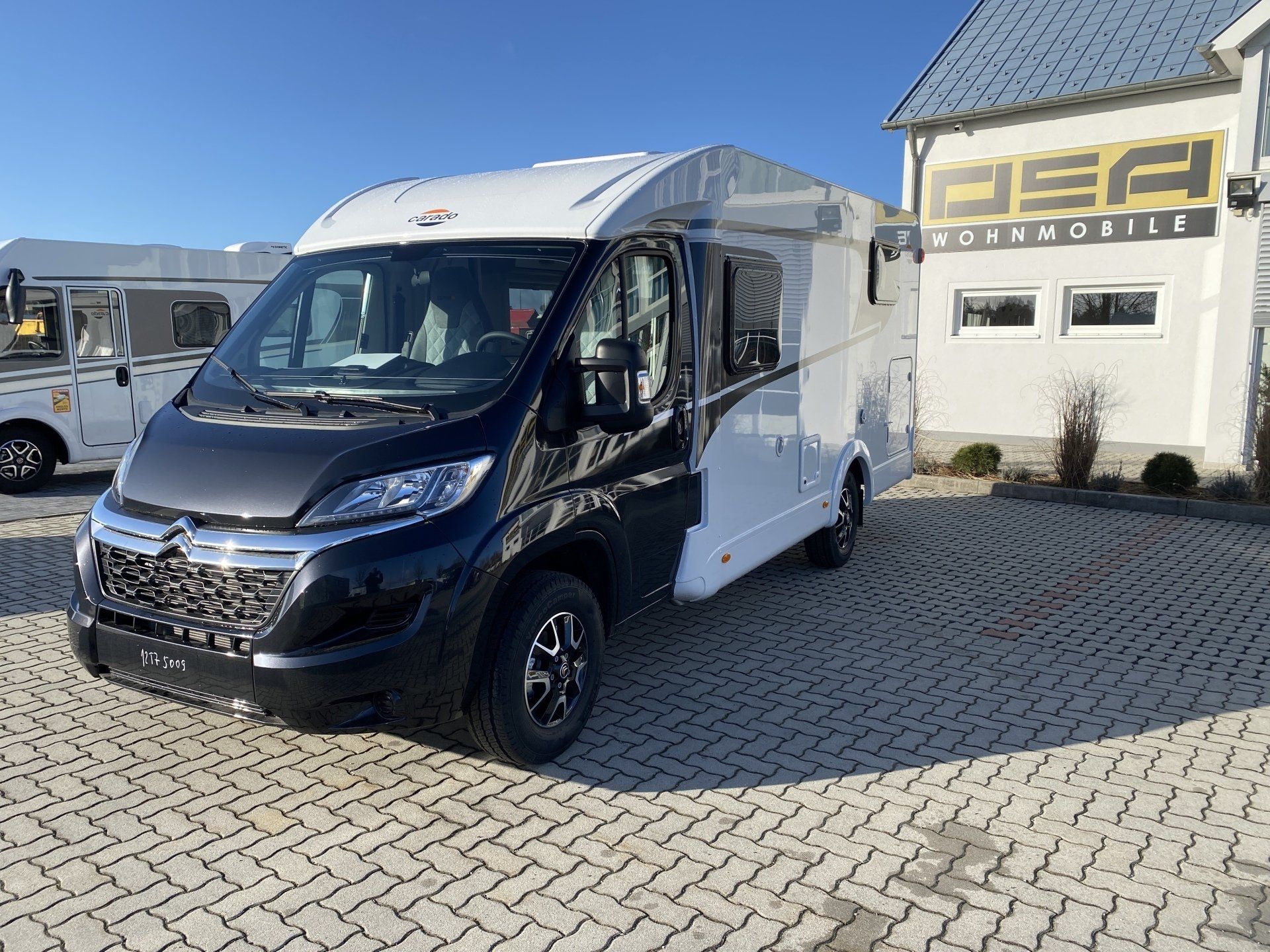 Ein schwarz - weißer Lieferwagen ist vor einem Gebäude geparkt.