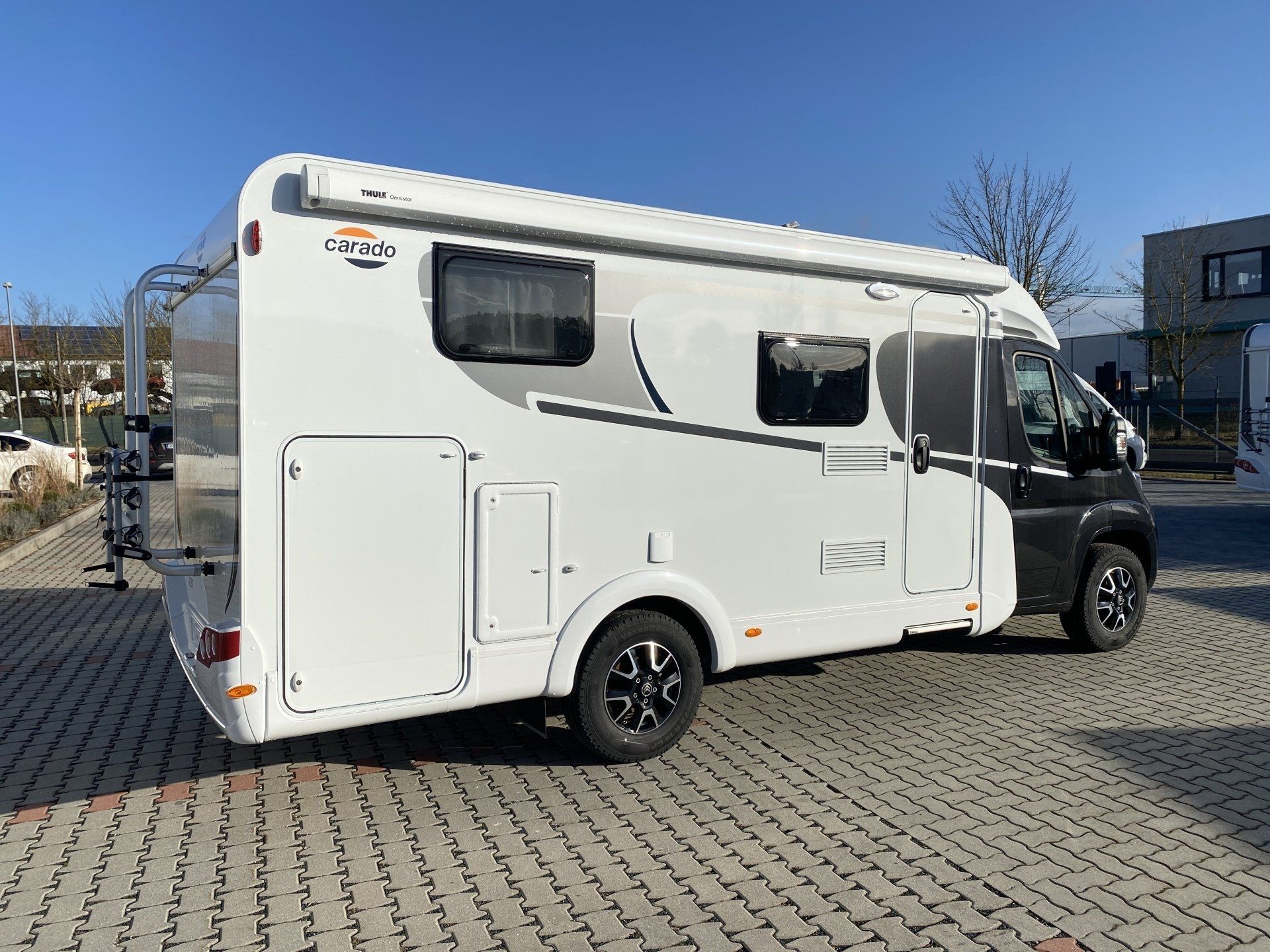 Ein weißes Wohnmobil steht auf einem Parkplatz.