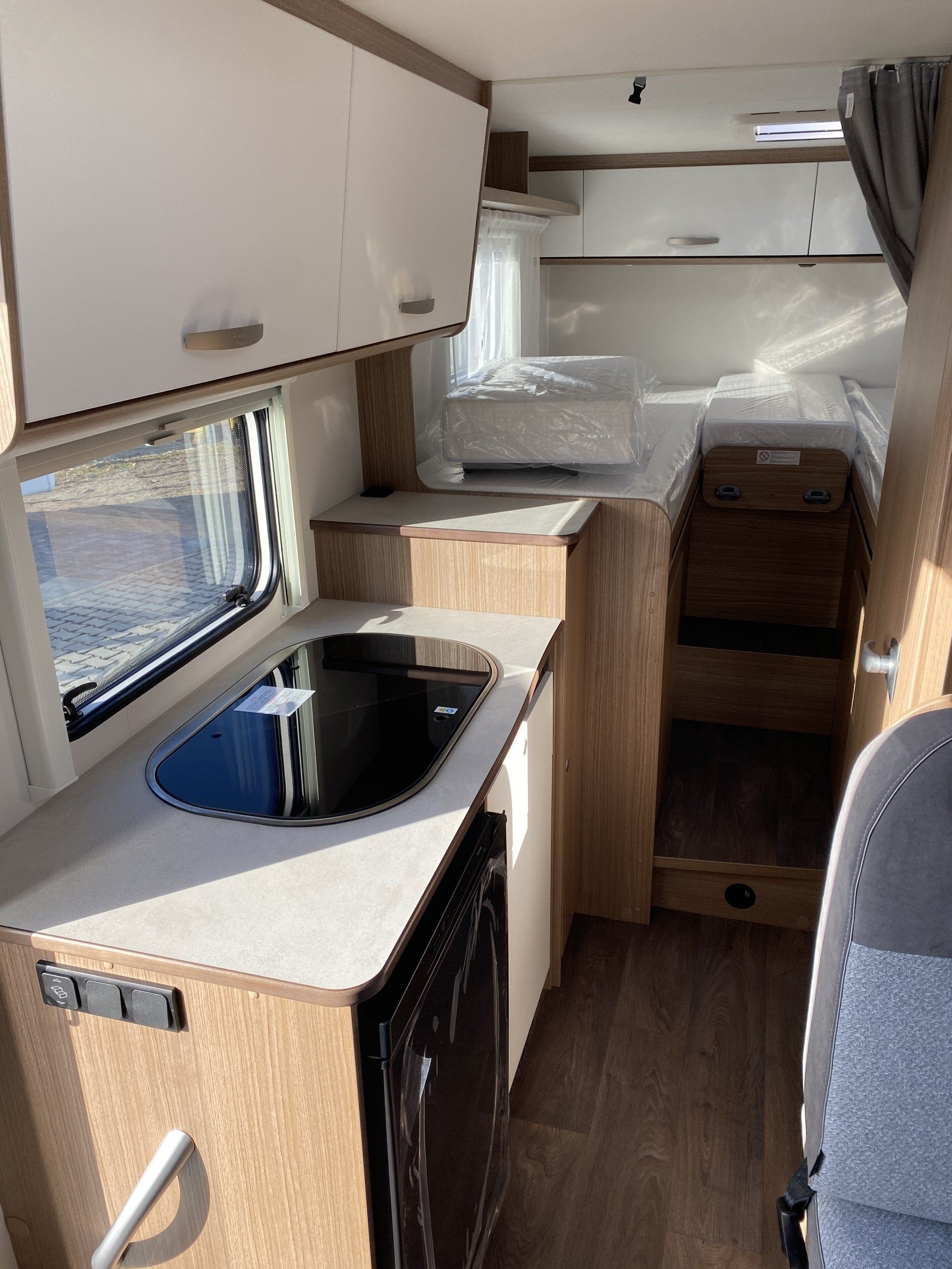Eine Küche im Wohnmobil mit Spüle, Herd und Kühlschrank.