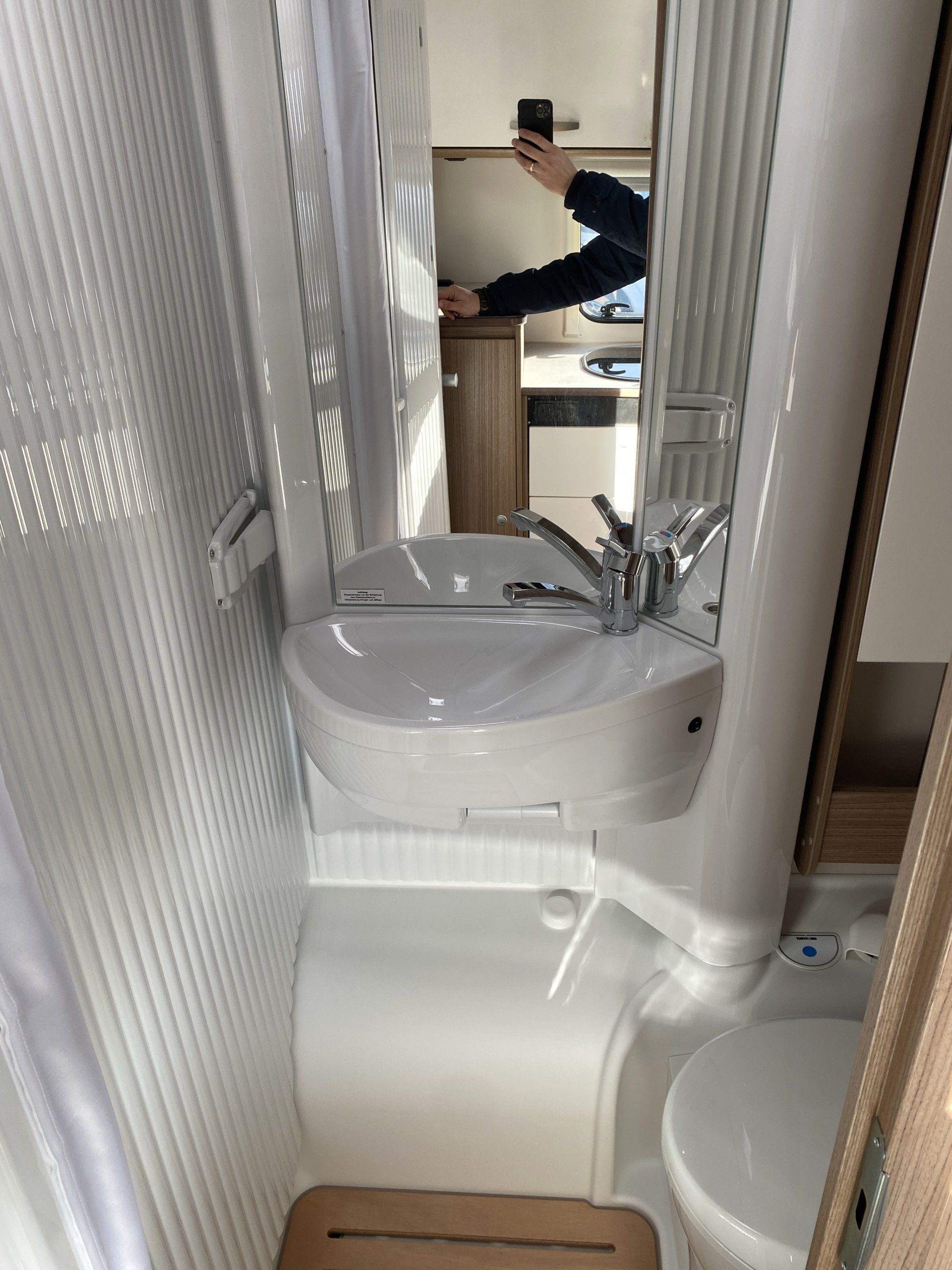 Ein Badezimmer mit Waschbecken, Toilette und Spiegel.