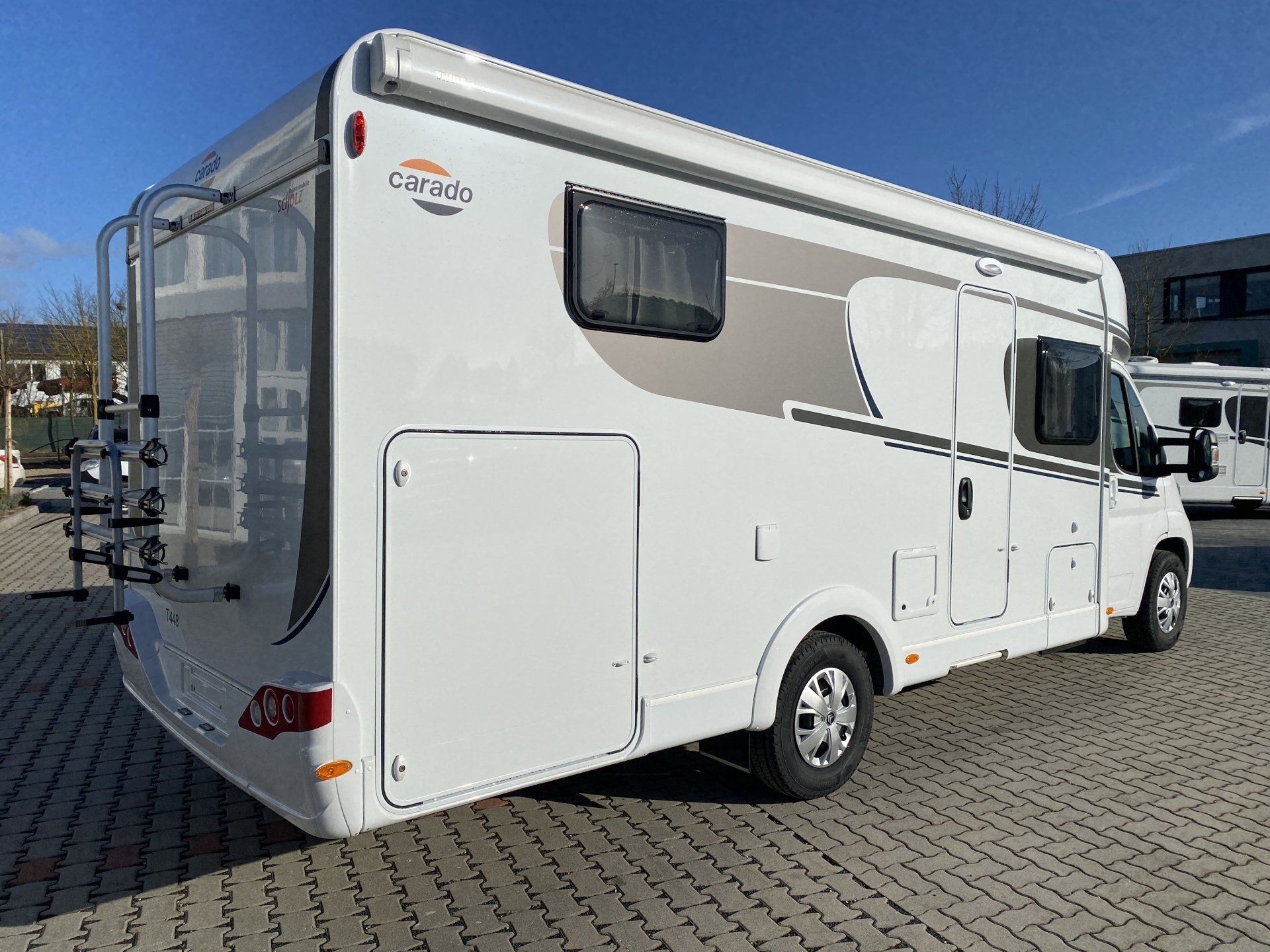 Ein weißes Wohnmobil steht auf einem Parkplatz.