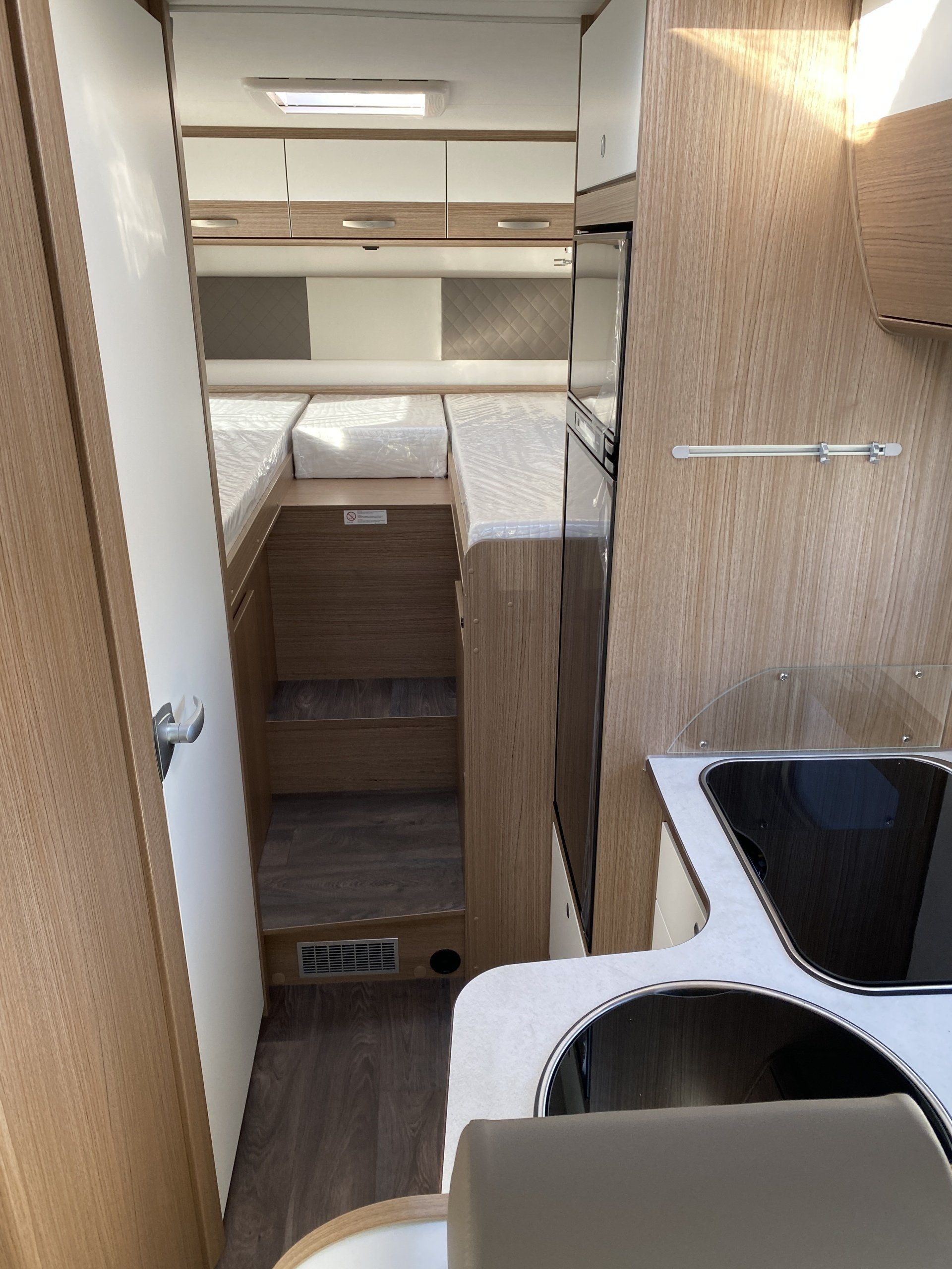 Eine Küche im Wohnmobil mit Herd und Spüle.