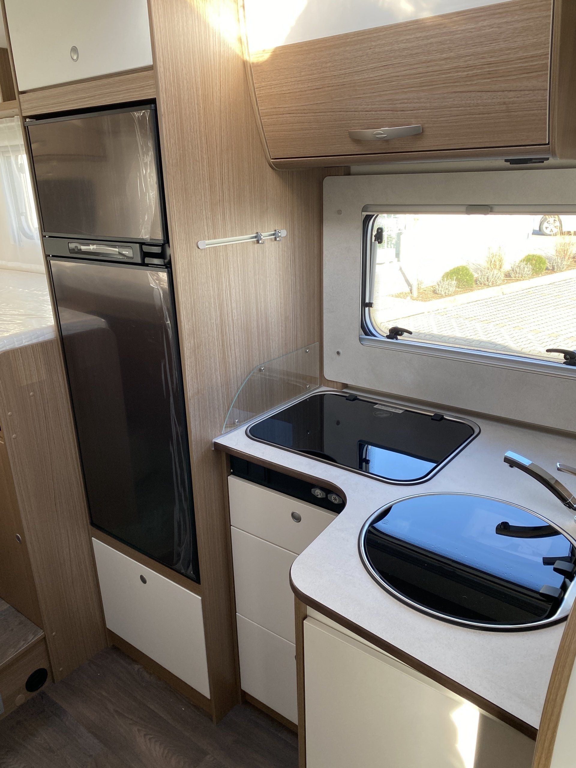 Eine Küche im Wohnmobil mit Spüle, Herd und Kühlschrank.