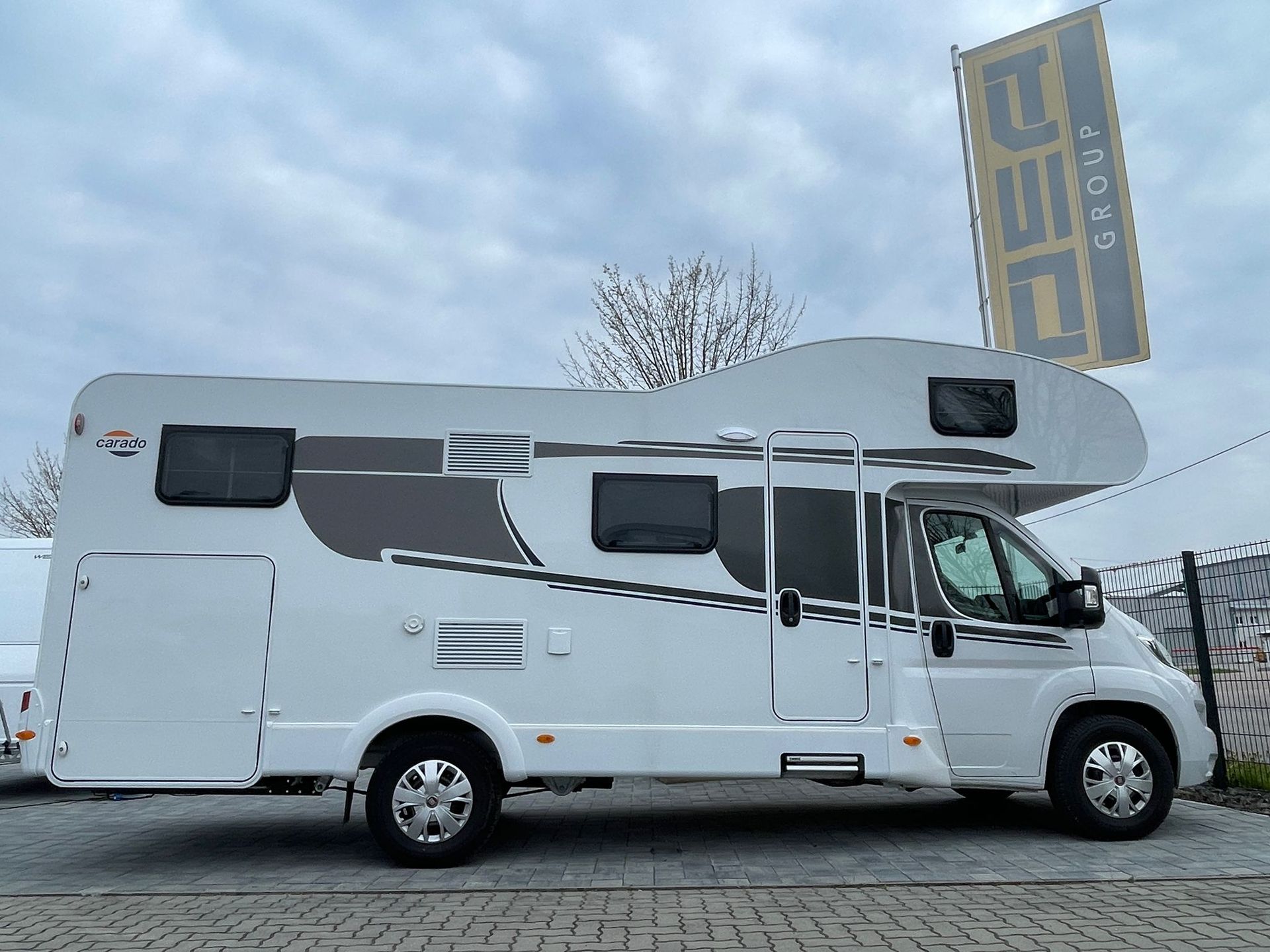 A white rv is parked on the side of the road.