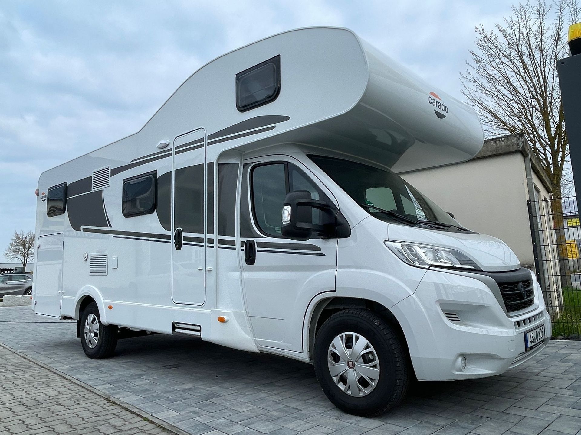 A white camper van is parked in a parking lot.