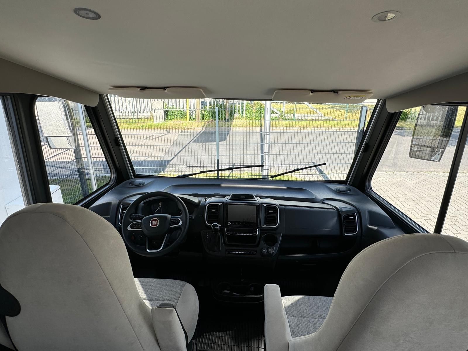 Der Innenraum eines Wohnmobils mit zwei Sitzen und einem Lenkrad.