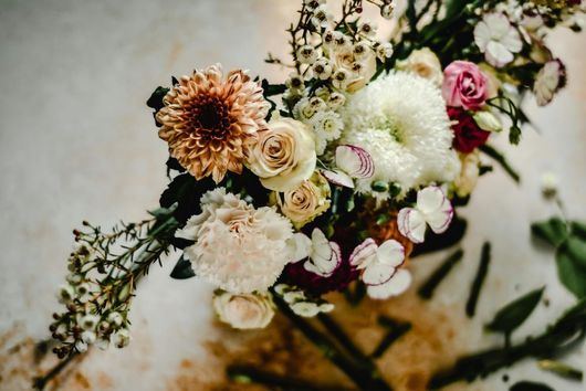 Assorted pastel flowers and greenery arranged in a soft, cascading bouquet