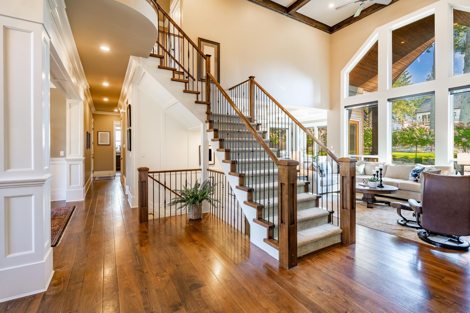 A large living room with hardwood floors and a staircase leading up to the second floor.
