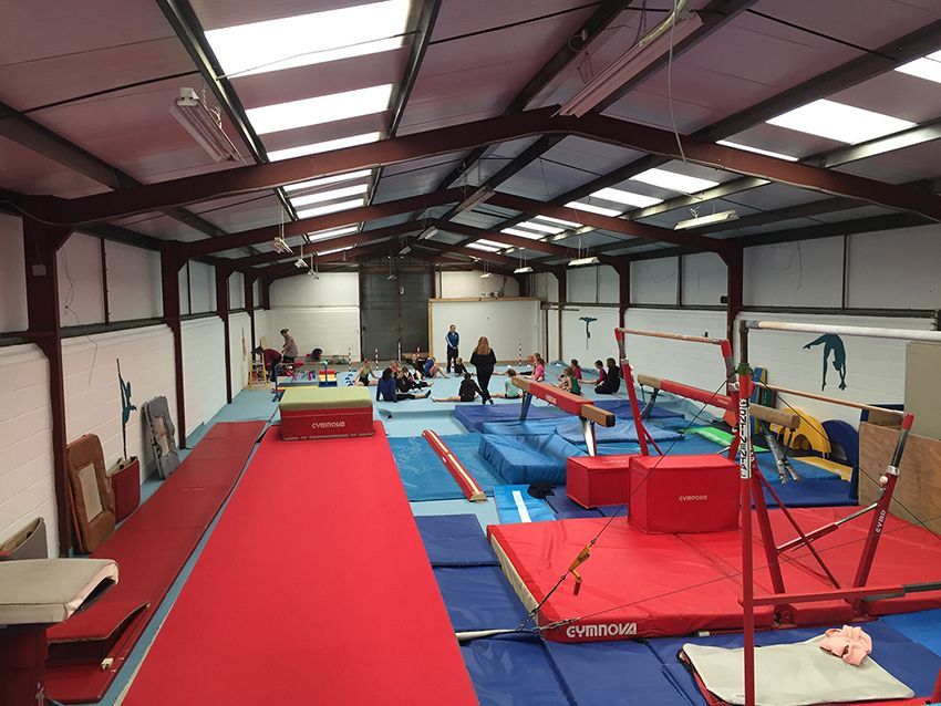 A large gym filled with a lot of equipment and people.