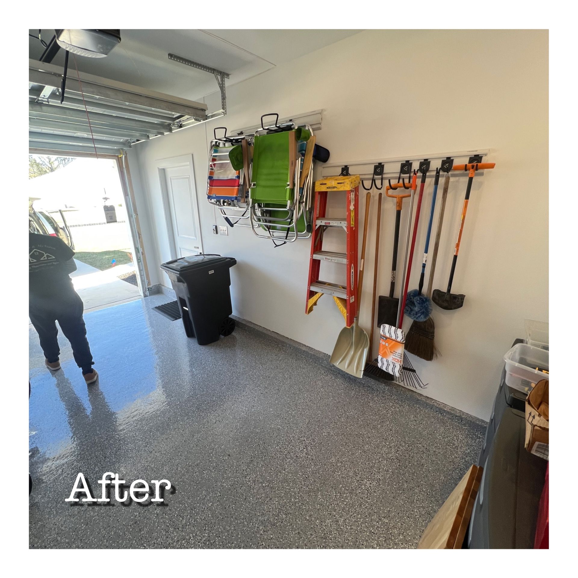 A person is standing in a garage with a ladder hanging on the wall.