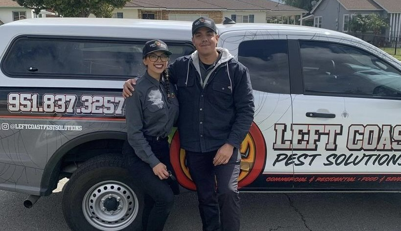 A man and a woman are standing in front of a truck that says left coast pest solutions.