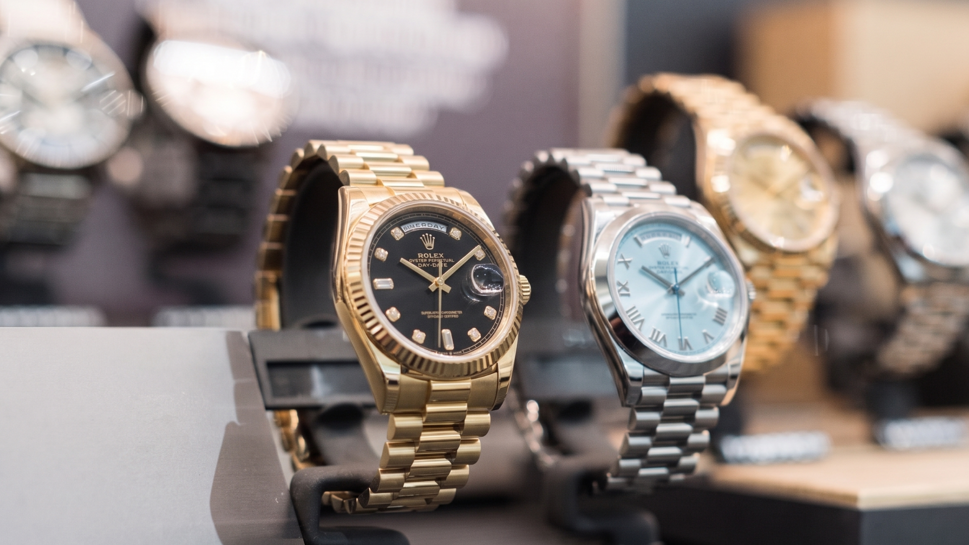 Gold and silver luxury wristwatches displayed on stands in a jewelry store