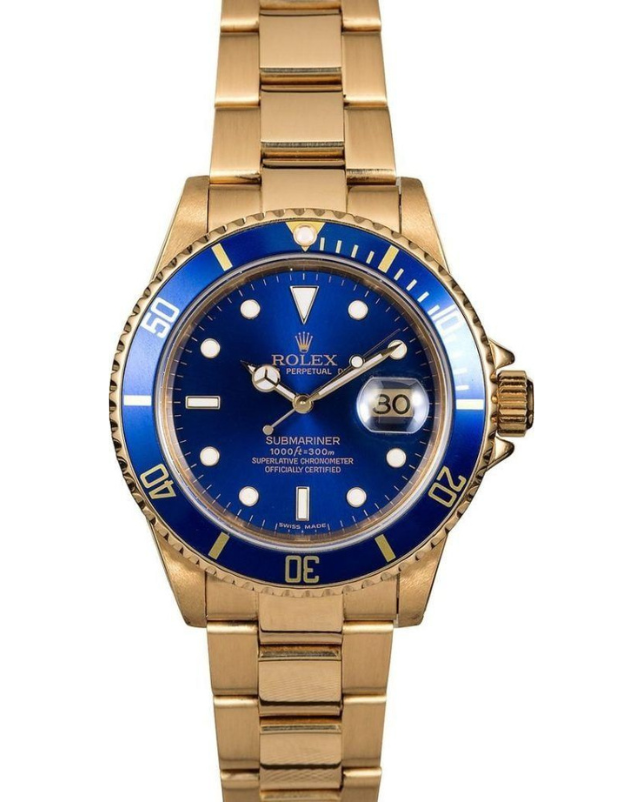 Gold Rolex watch with blue bezel and dial, showing the date at 3 o’clock.