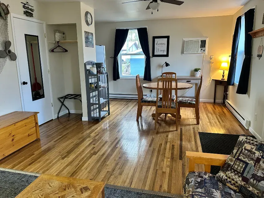 A living room with a table and chairs and a ceiling fan.