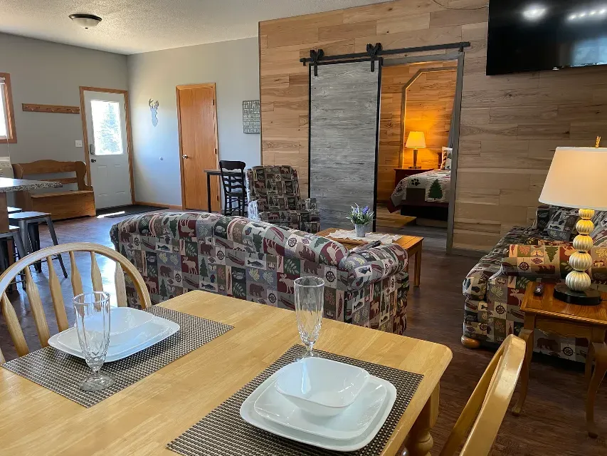 A living room with a dining table and chairs and a sliding barn door.