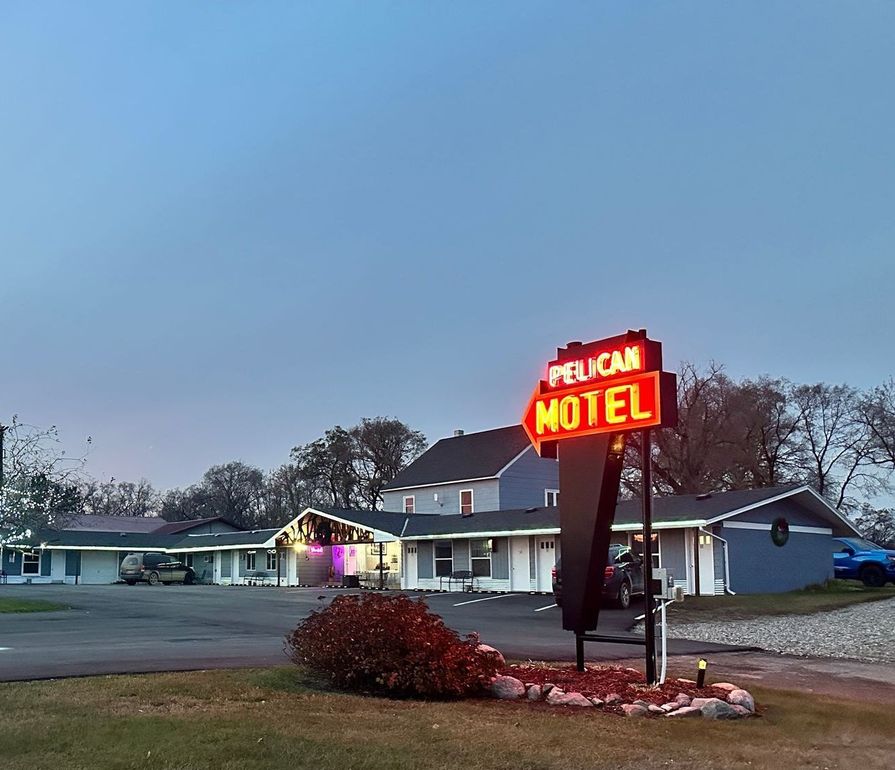 A pelican motel sign is in front of a motel