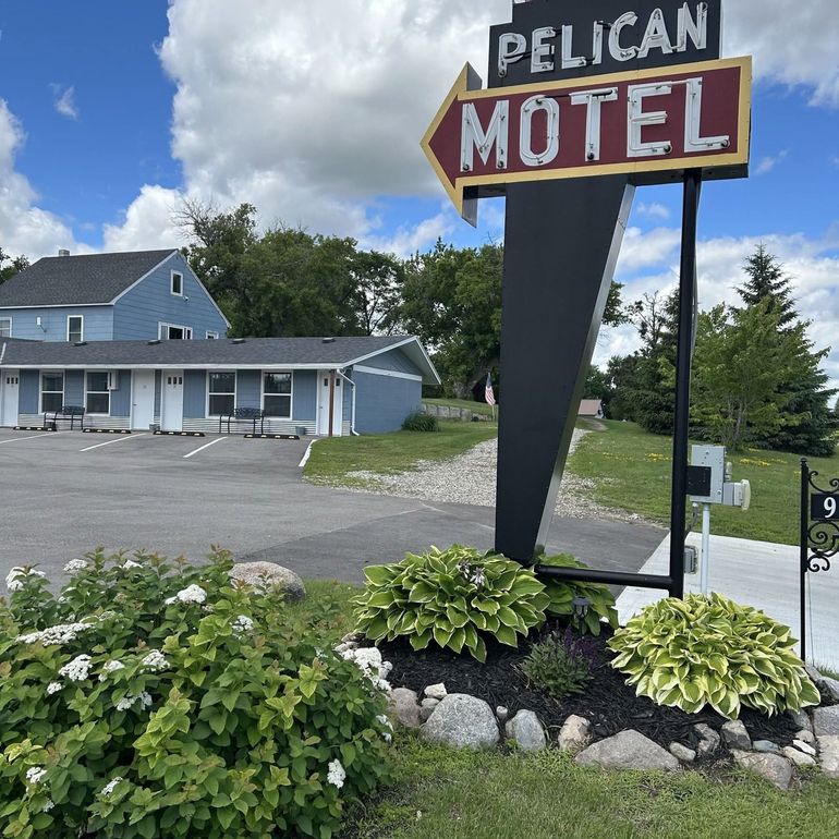 A pelican motel sign is in front of a motel