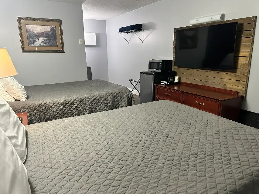 A hotel room with two beds and a flat screen tv.