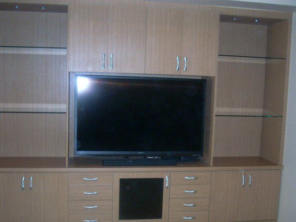 A large flat screen tv sits in a wooden entertainment center