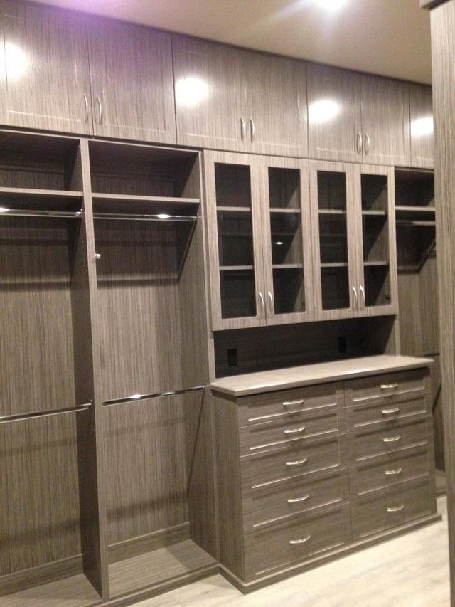 A walk in closet with lots of shelves and drawers.