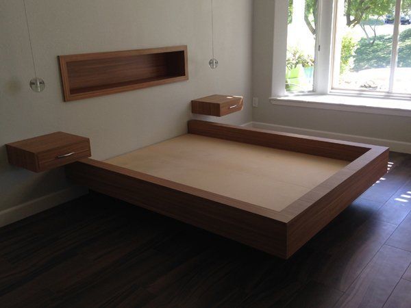 A bedroom with a wooden bed and two floating nightstands