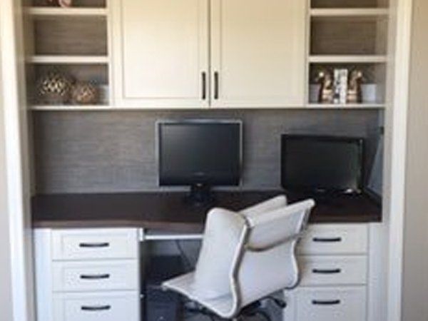 There is a desk with a computer on it and a chair.
