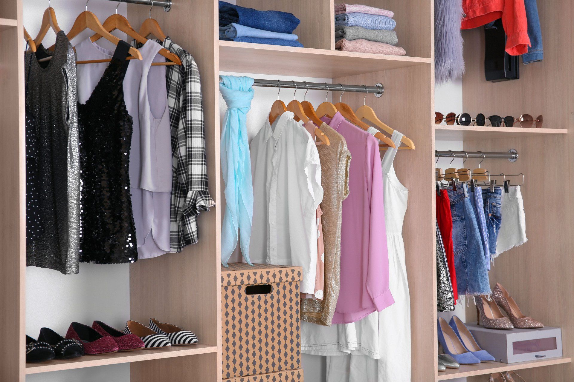 A closet filled with lots of clothes and shoes.