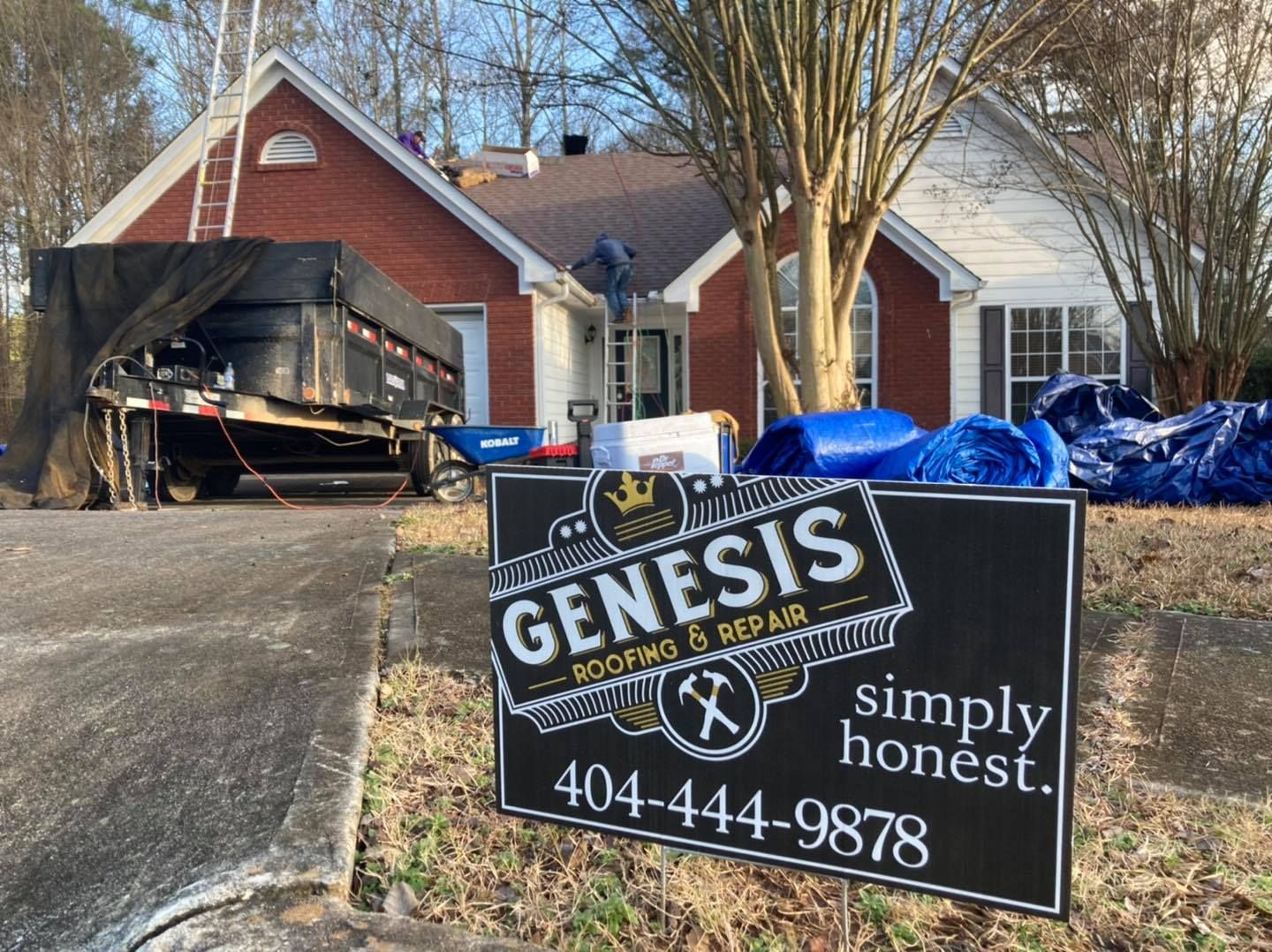 A Genesis Roofing sign in front of a brick house with roofing equipment, a trailer, and roofers.