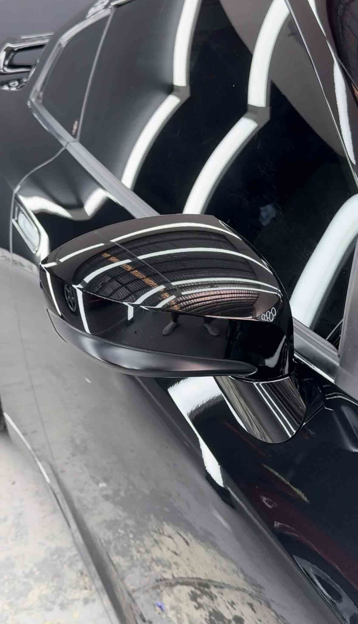 Black car side mirror with damage visible on top.