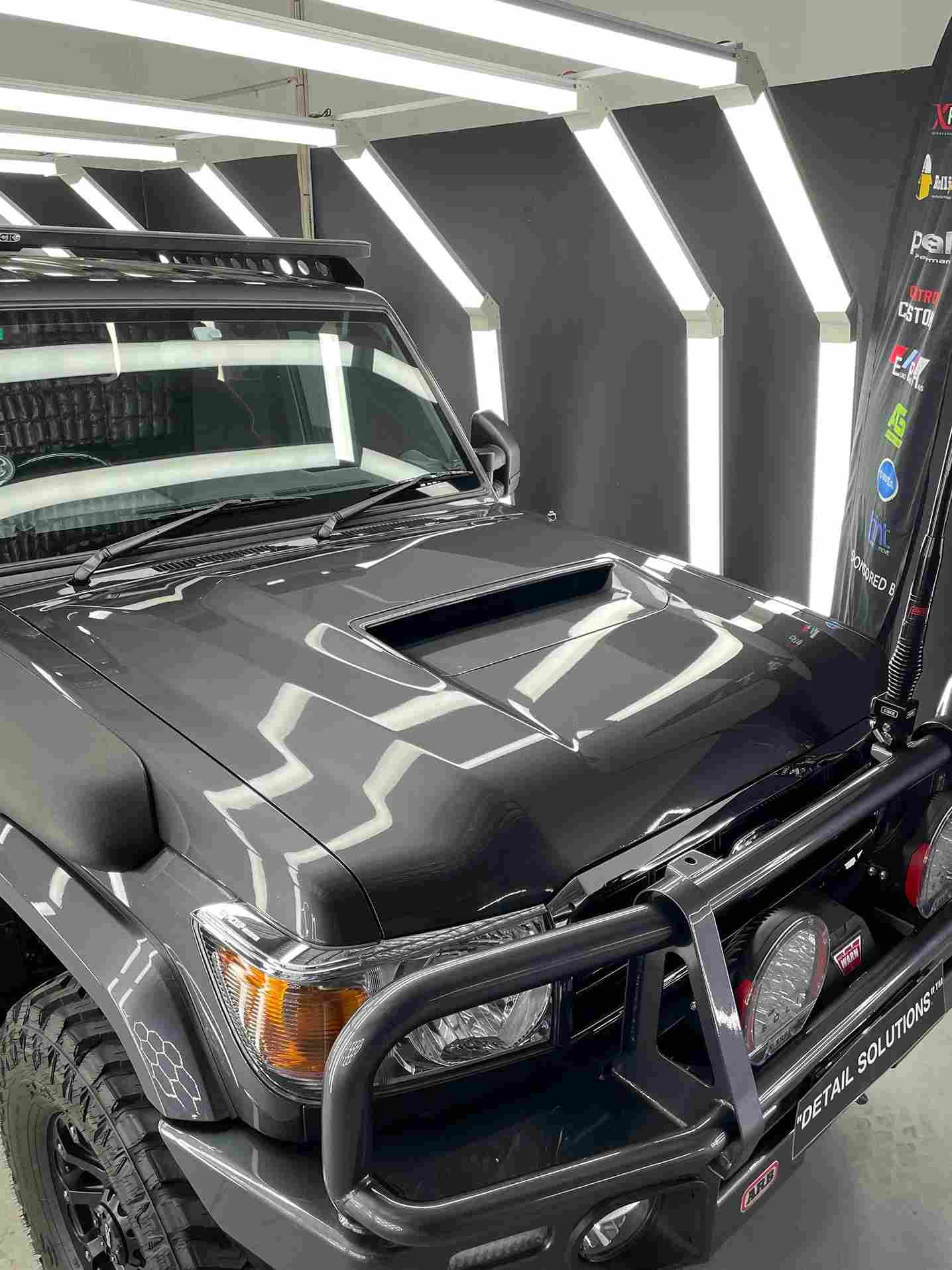 Dark gray SUV with a black bull bar and roof rack.