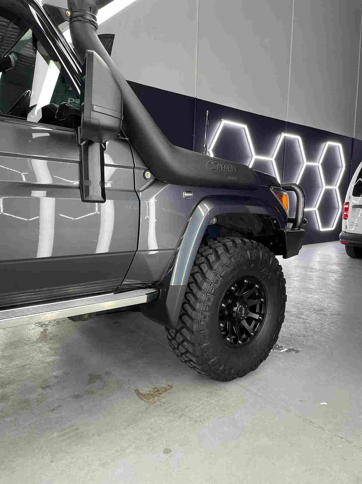 Dark gray off-road SUV with a snorkel, large tires, and a black rim, angled toward the camera.