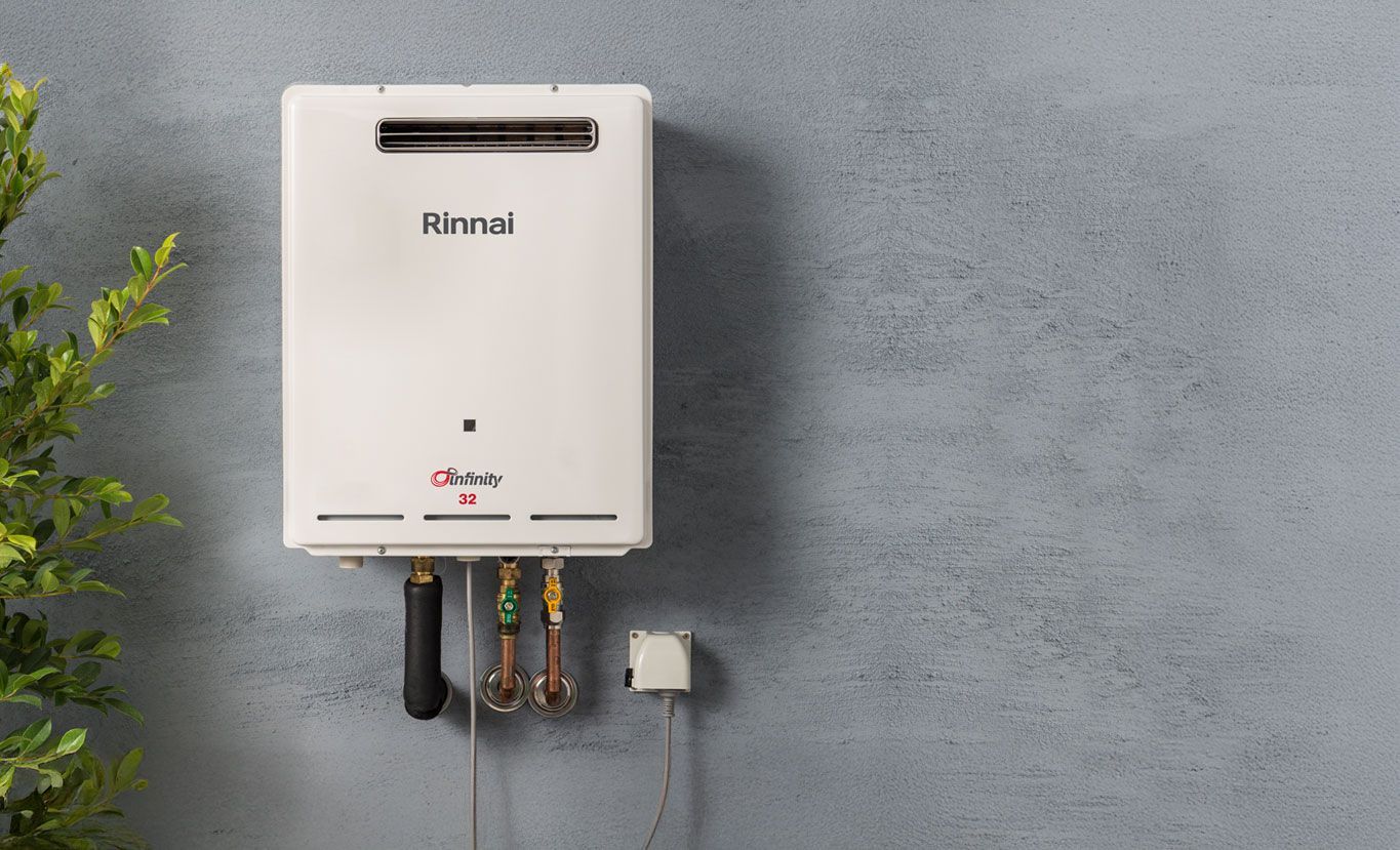 White Wall-mounted Water Heater With Pipes and Electrical Outlet — Forster Hotwater in Nabiac, NSW